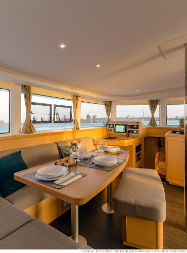 Luxurious interior of 2025 Lagoon 42 Millenium yacht with elegant dining area and navigation station.