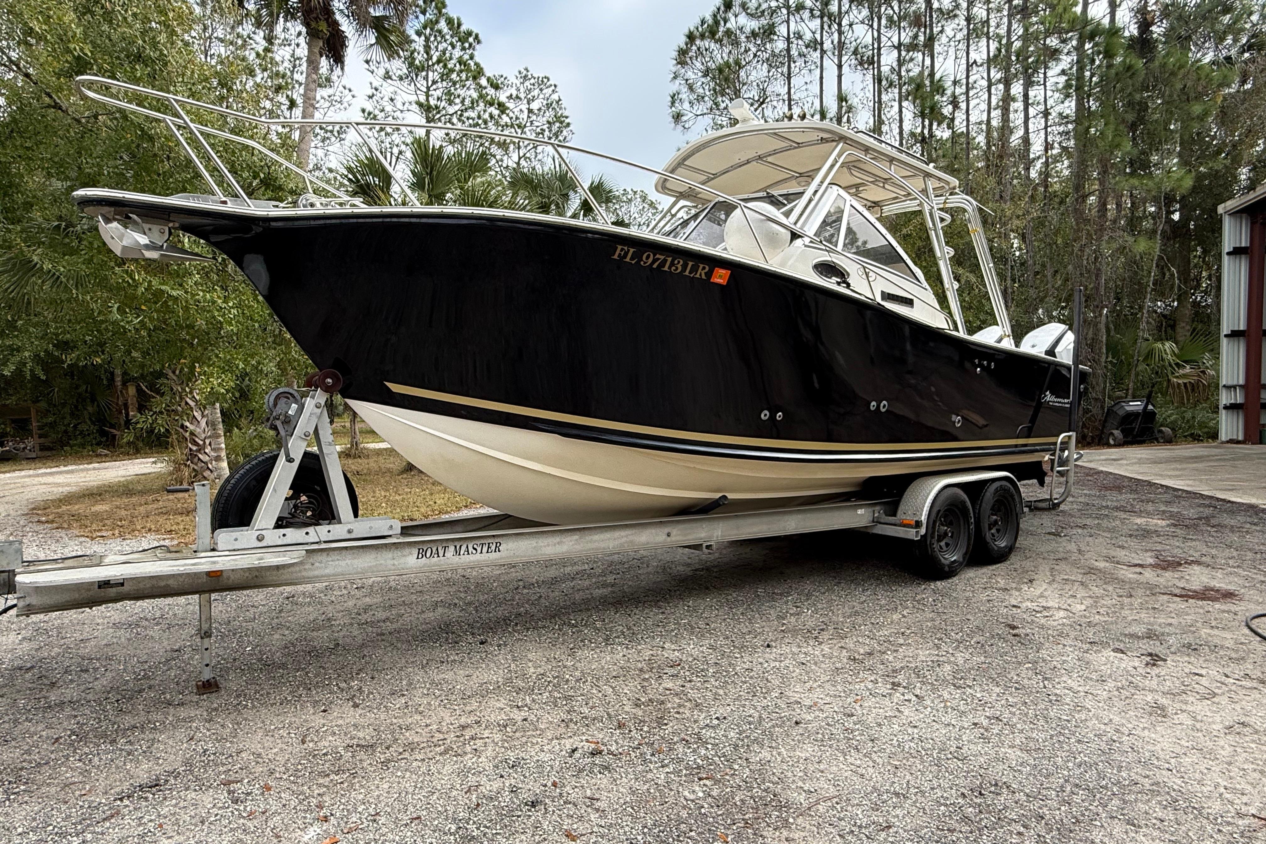 2002 Albemarle 265 Express Fisherman boat on trailer, surrounded by trees.