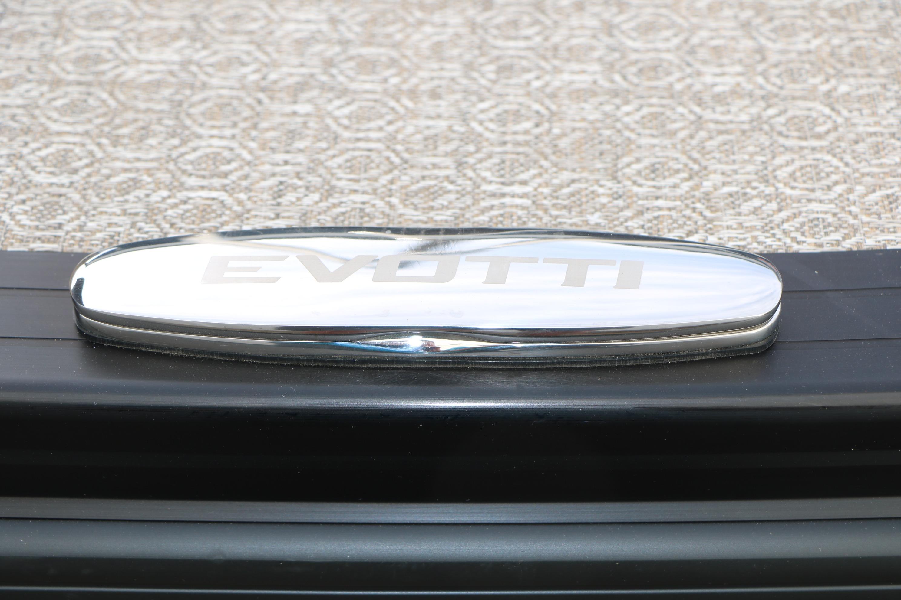 Chrome Evotti logo on 2026 Evotti 523CS vehicle, textured background.