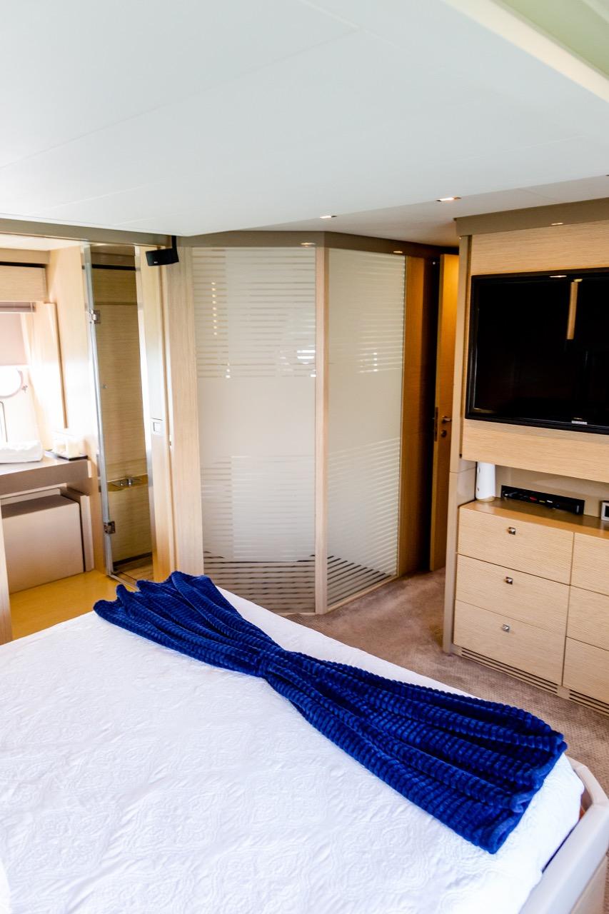 Luxurious bedroom on a 2013 Ferretti Yachts 720 with modern amenities.