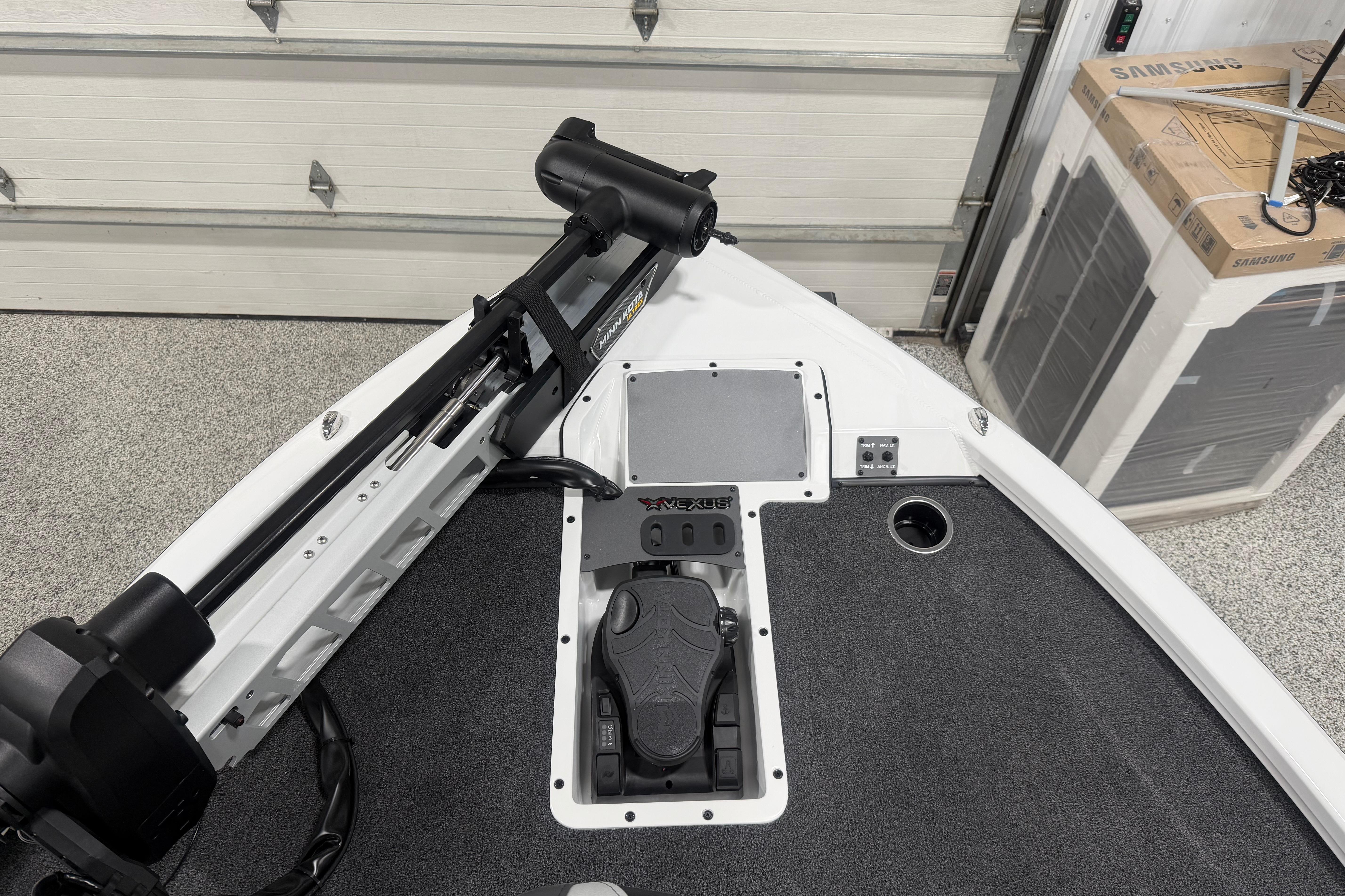2026 Vexus AVX 2085S boat deck with trolling motor and control panel in a garage.