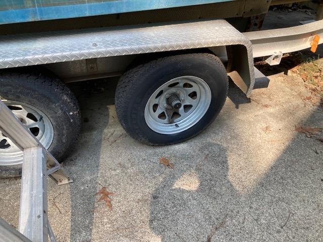 Trailer wheels of a 2002 Sea Pro 235 Walk Around boat on concrete.