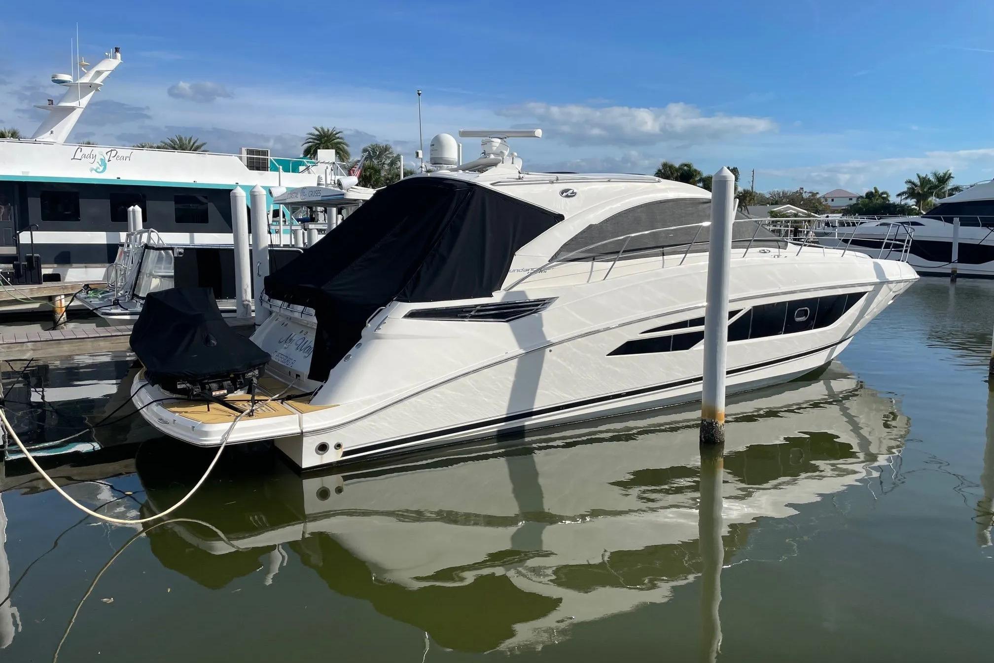2016 Sea Ray Sundancer 510 yacht docked in a marina under clear blue skies.