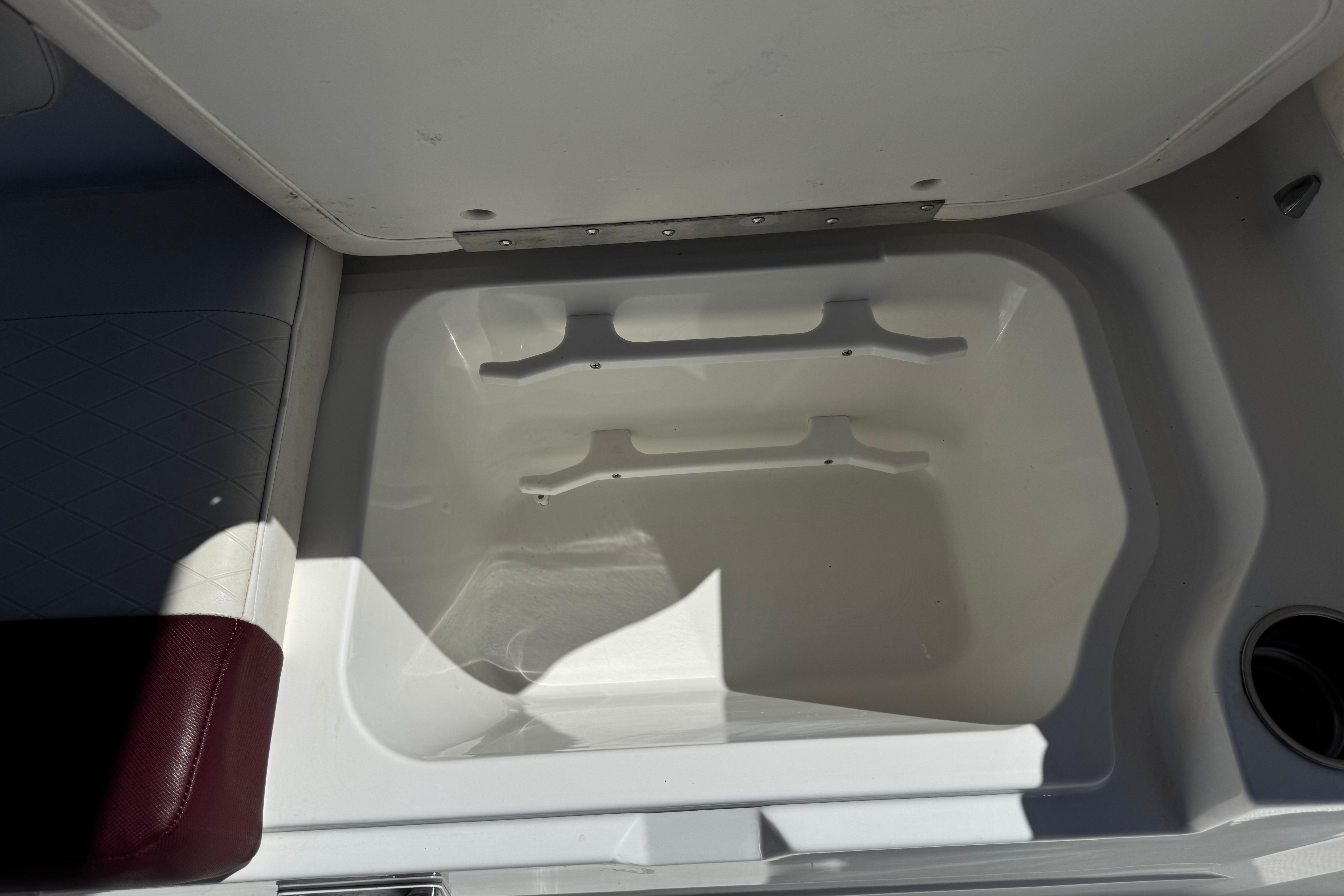 Open storage compartment in a 2017 Tahoe 2150 boat, featuring white interior.