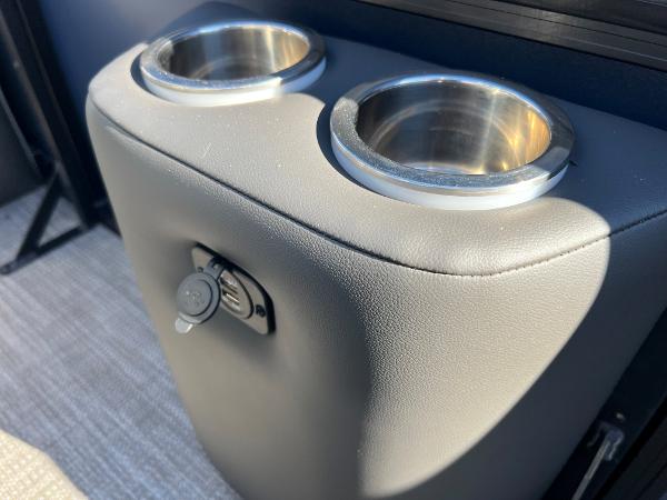Close-up of two stainless steel cup holders on a padded boat seat.