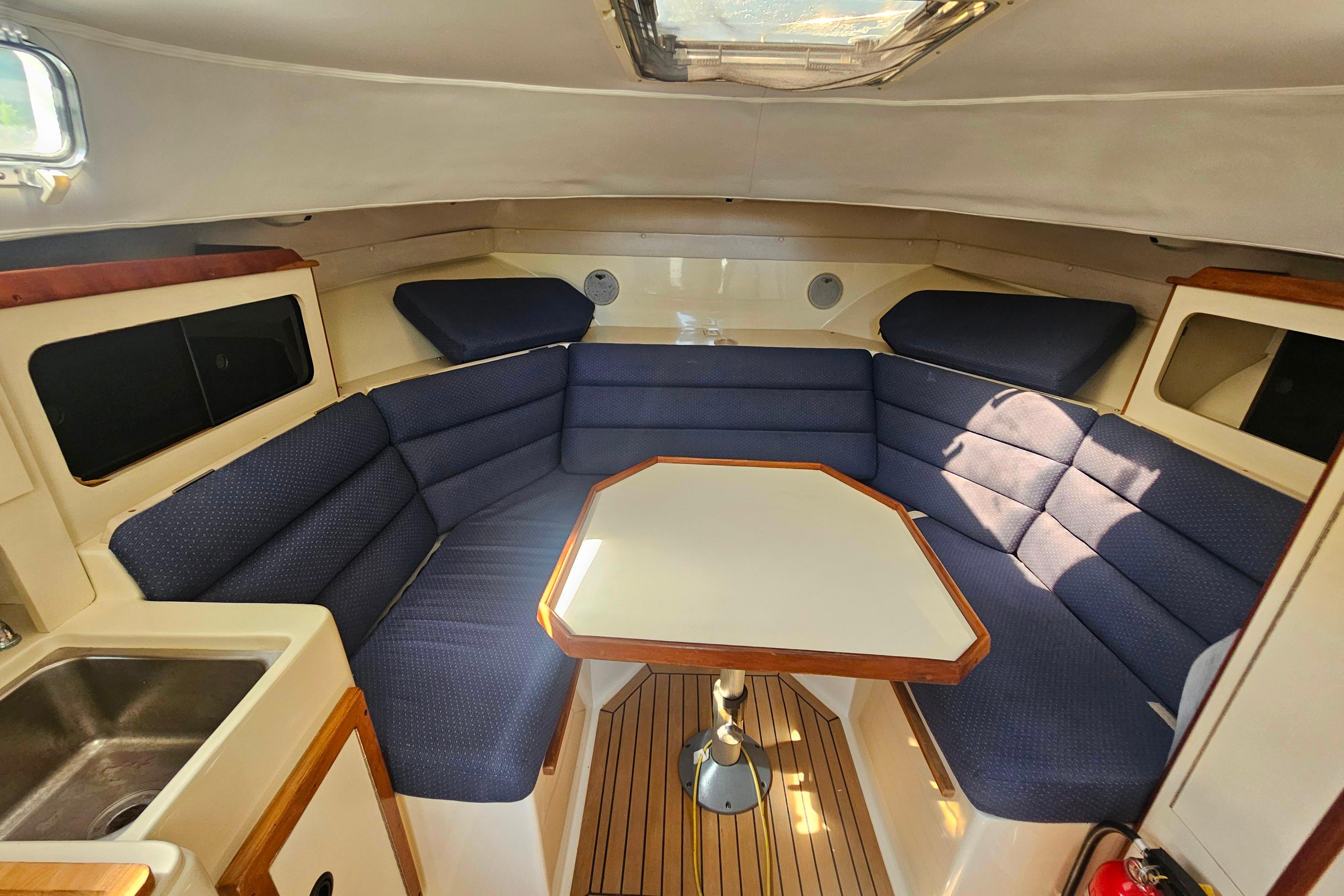 1999 Albin 28 Tournament Express cabin with blue seating and a central table.