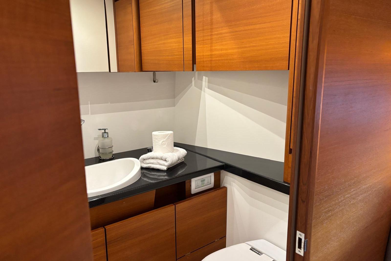 Luxurious bathroom in 2022 Solaris 55 yacht with wooden cabinets and modern fixtures.