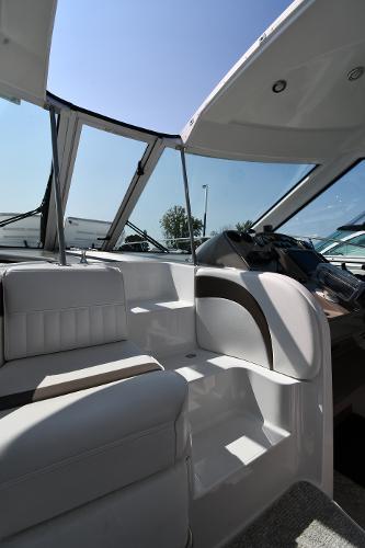 2010 Cruisers Yachts 390 Sports Coupe interior with seating and helm, under clear blue sky.