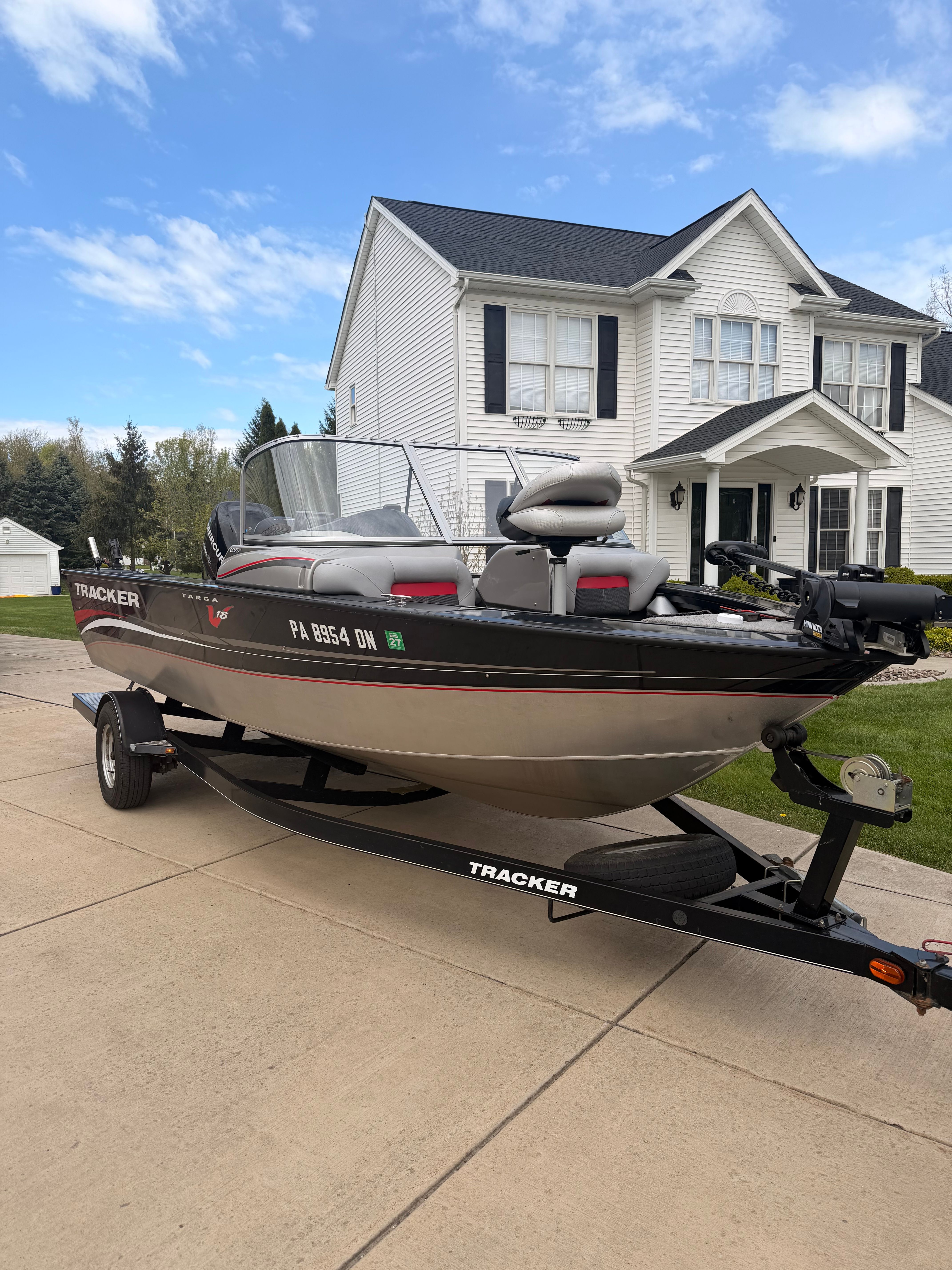 2013 Bass Tracker Targa V-18 WT boat parked in front of a house.