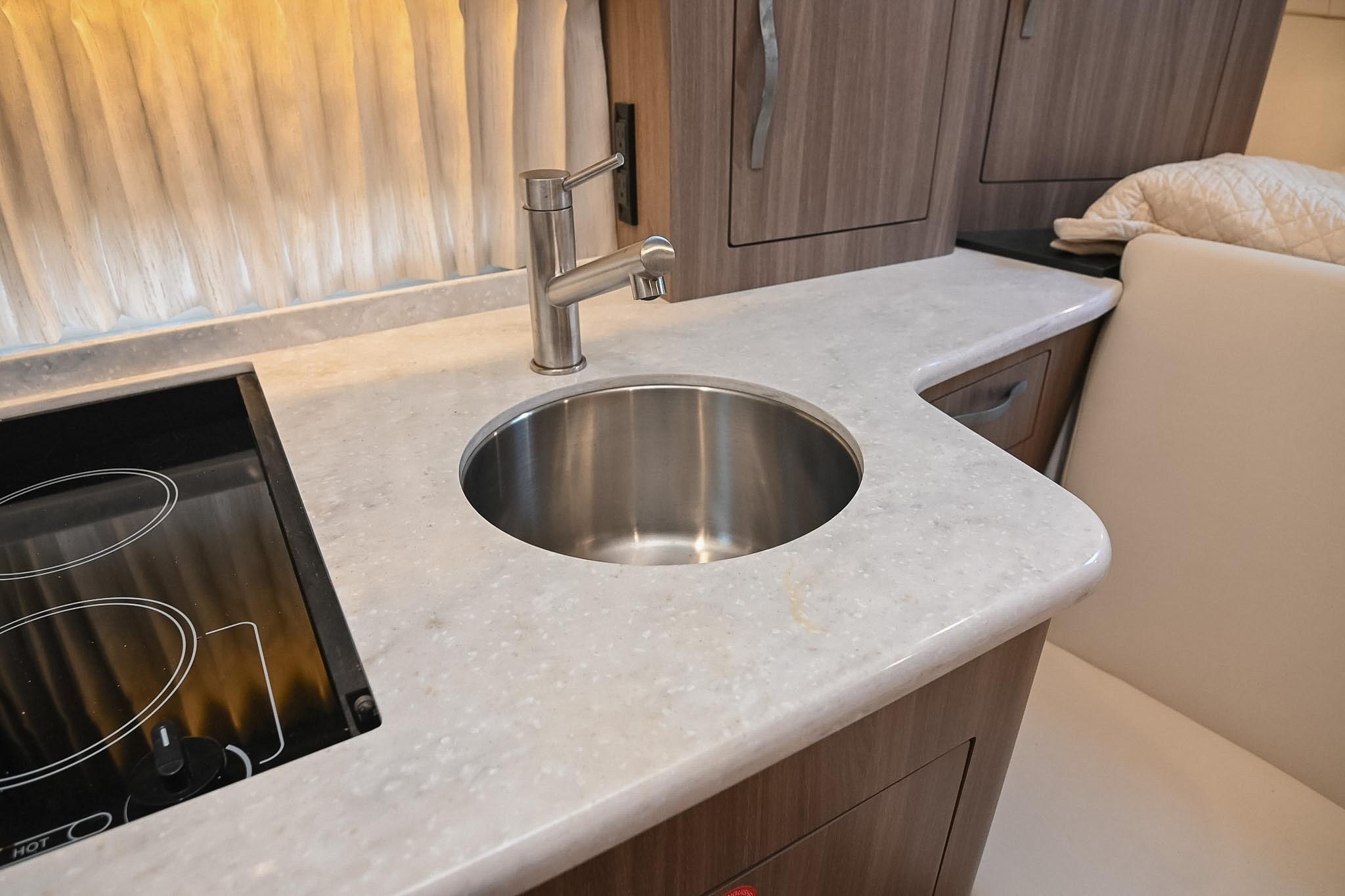 Modern kitchen area in 2021 Regal 33 Express yacht with sink and stovetop.