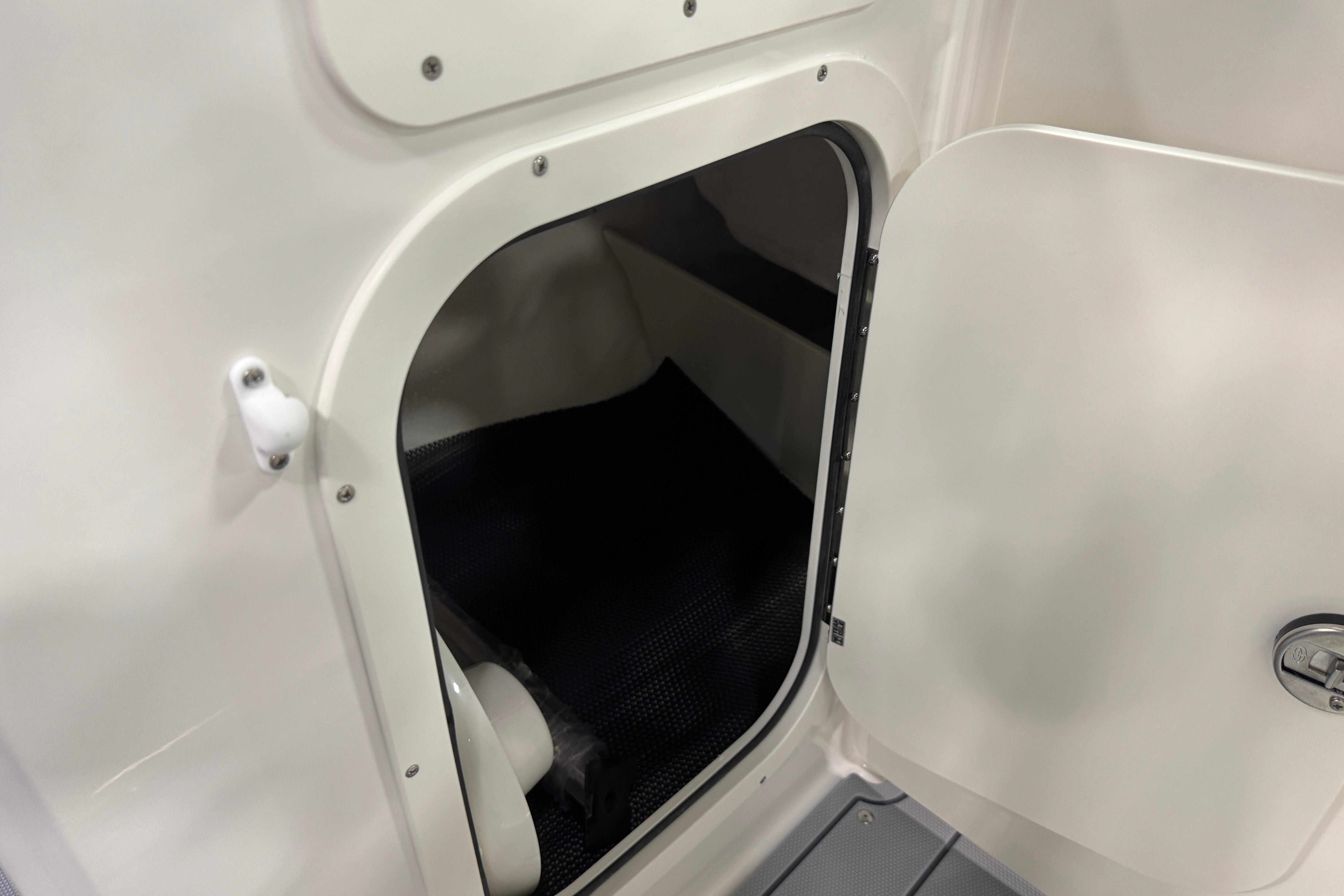 2026 Chaparral 23 SSi boat storage compartment with open door, showcasing interior space.