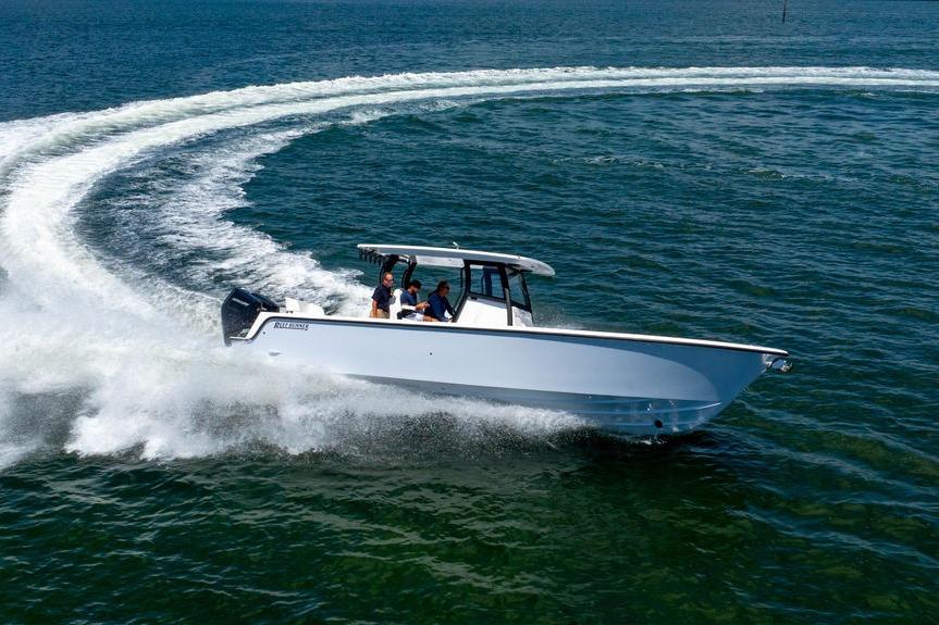 2027 Reef Runner 340 boat making a sharp turn on open water.
