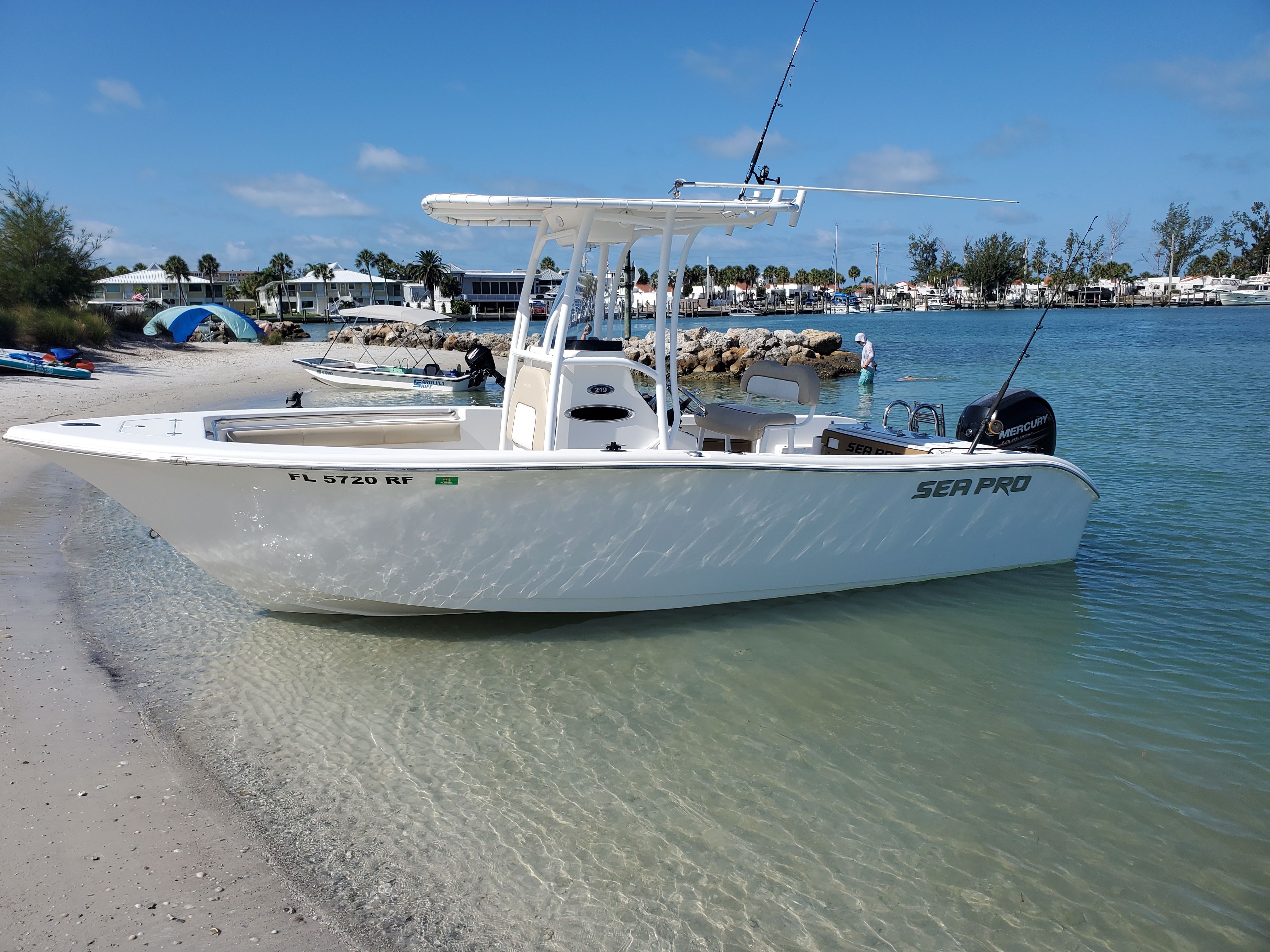 2017 Sea Pro 219 Center Console on a beach with clear water and blue sky.