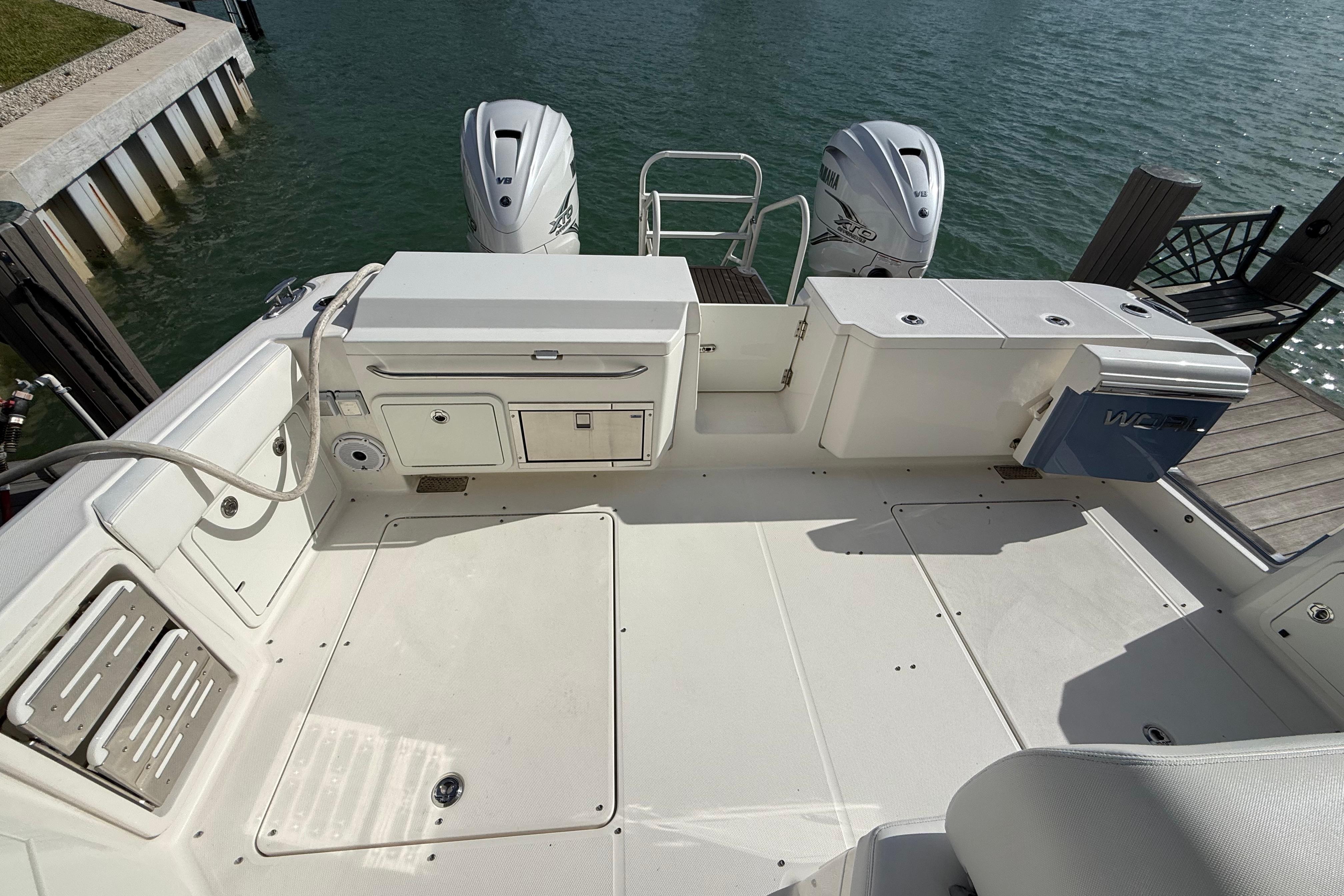 World Cat 400 DC-X 2021 boat deck with twin engines, docked by the water.