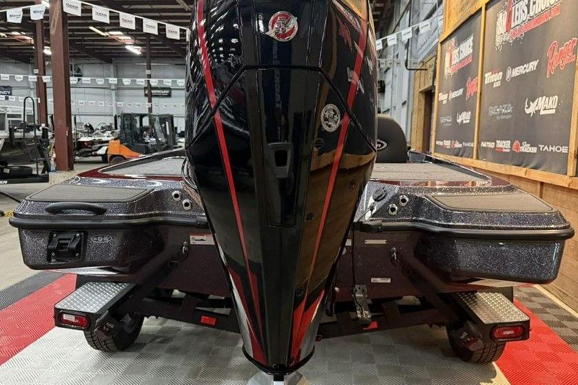 2026 Triton 20XP Patriot boat in showroom, featuring sleek black and red design.