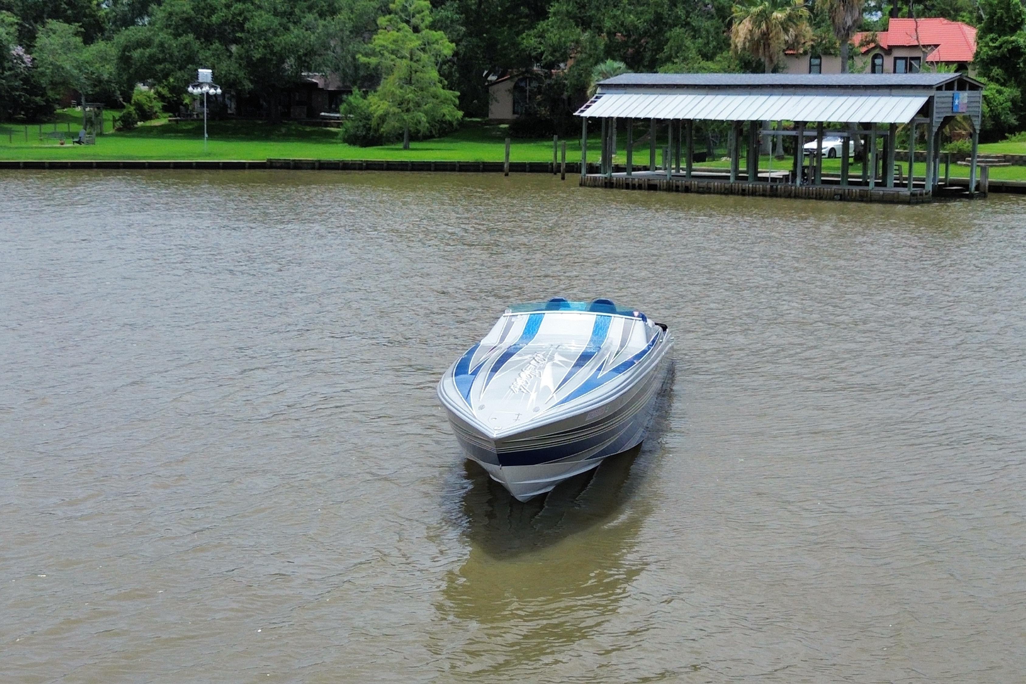 2013 Nor-Tech 477 SPX Vee Bottom boat on a calm river near a dock.