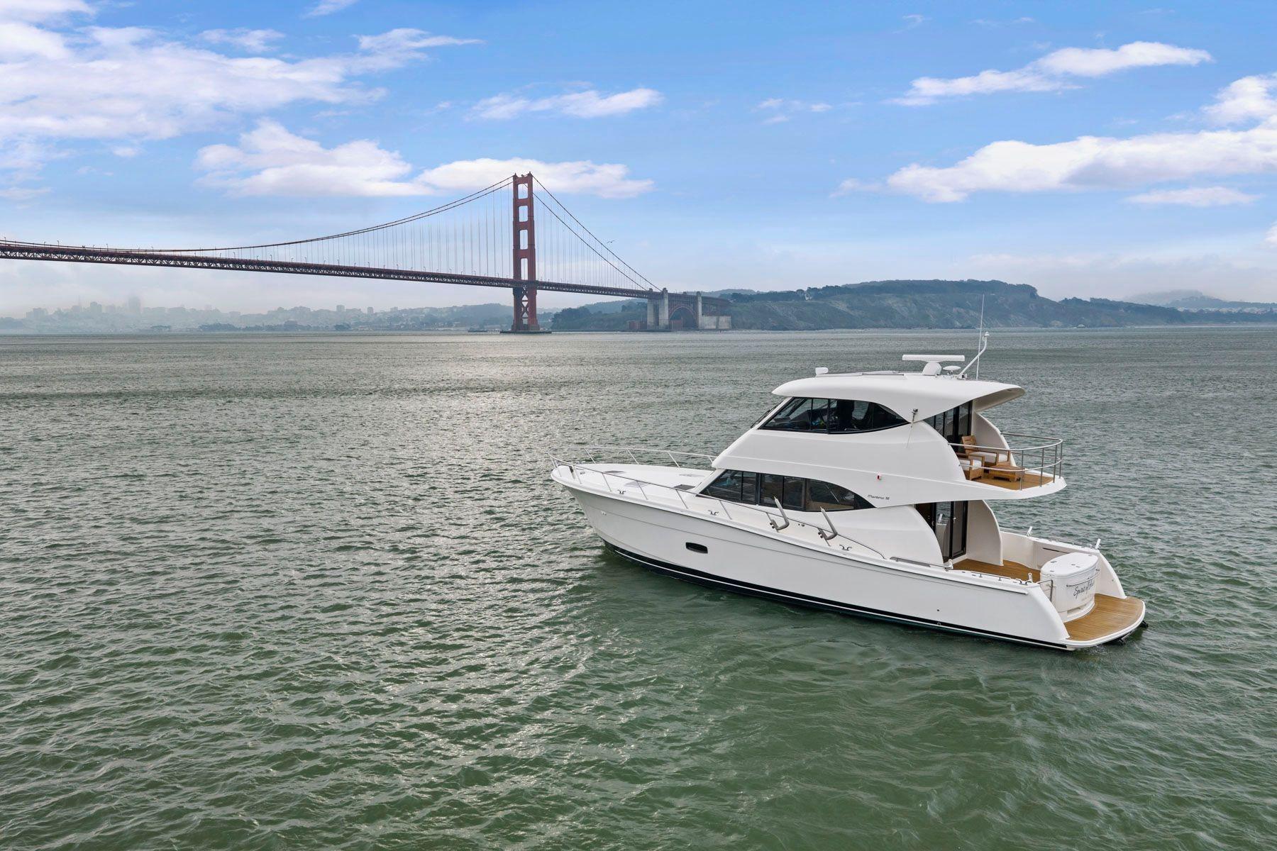 2014 Maritimo M50 yacht cruising near iconic bridge on a clear day.