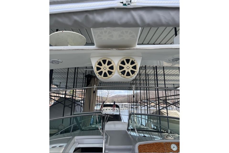 1999 Formula 400 Super Sport boat with dual speakers under a covered dock.