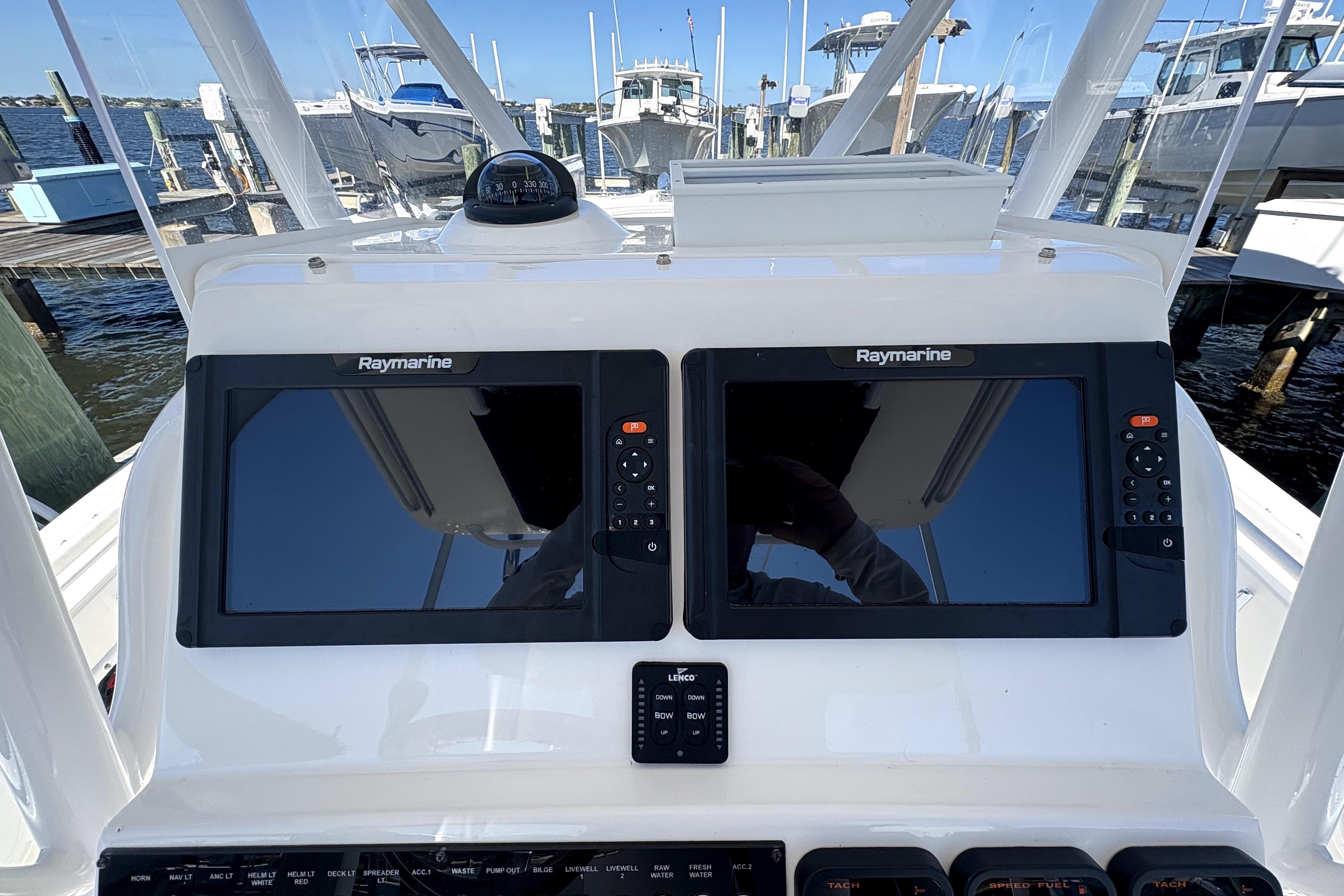Edgewater 245CC 2015 boat dashboard with dual Raymarine displays at a marina.
