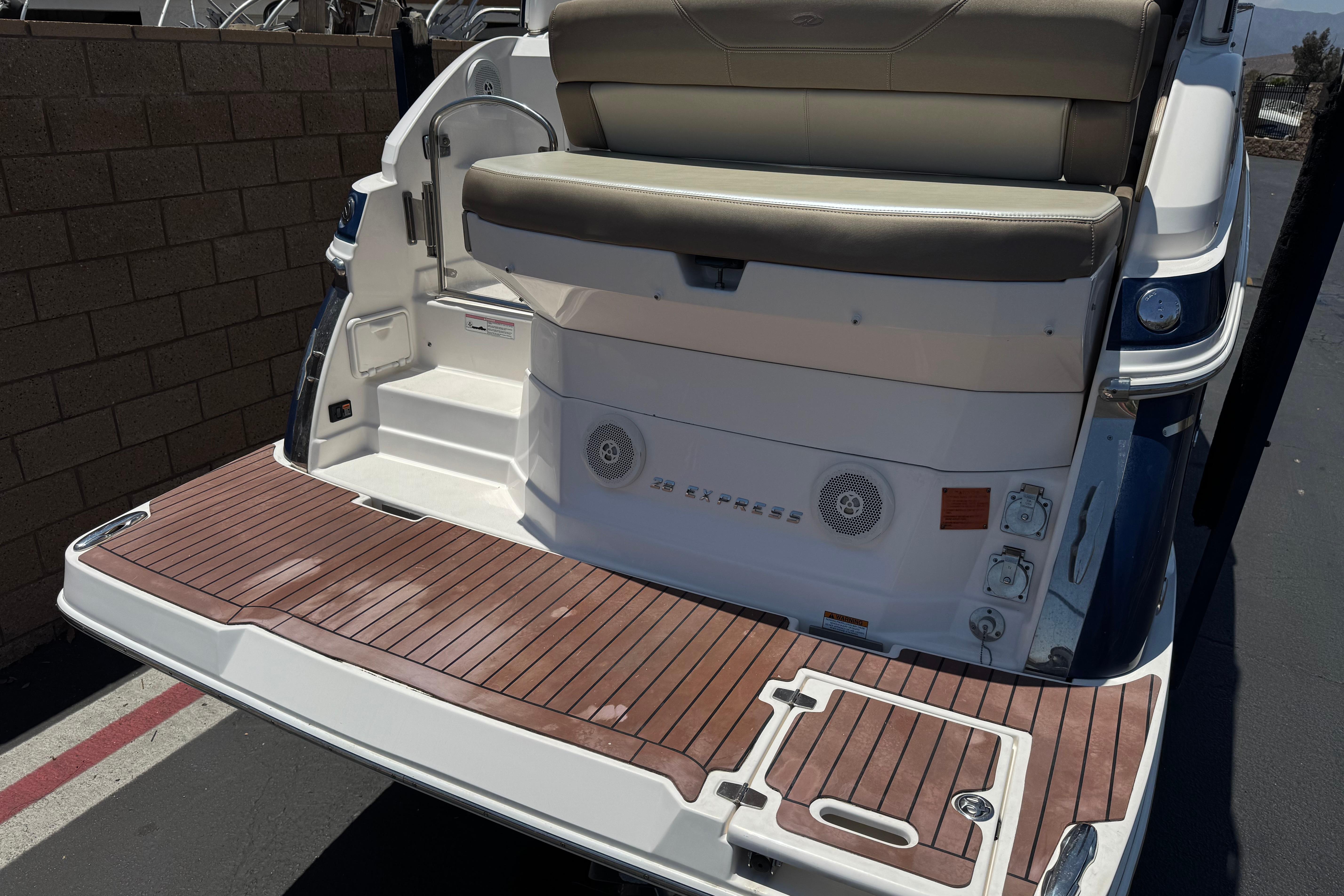 2013 Regal 28 Express boat with teak swim platform and seating area.