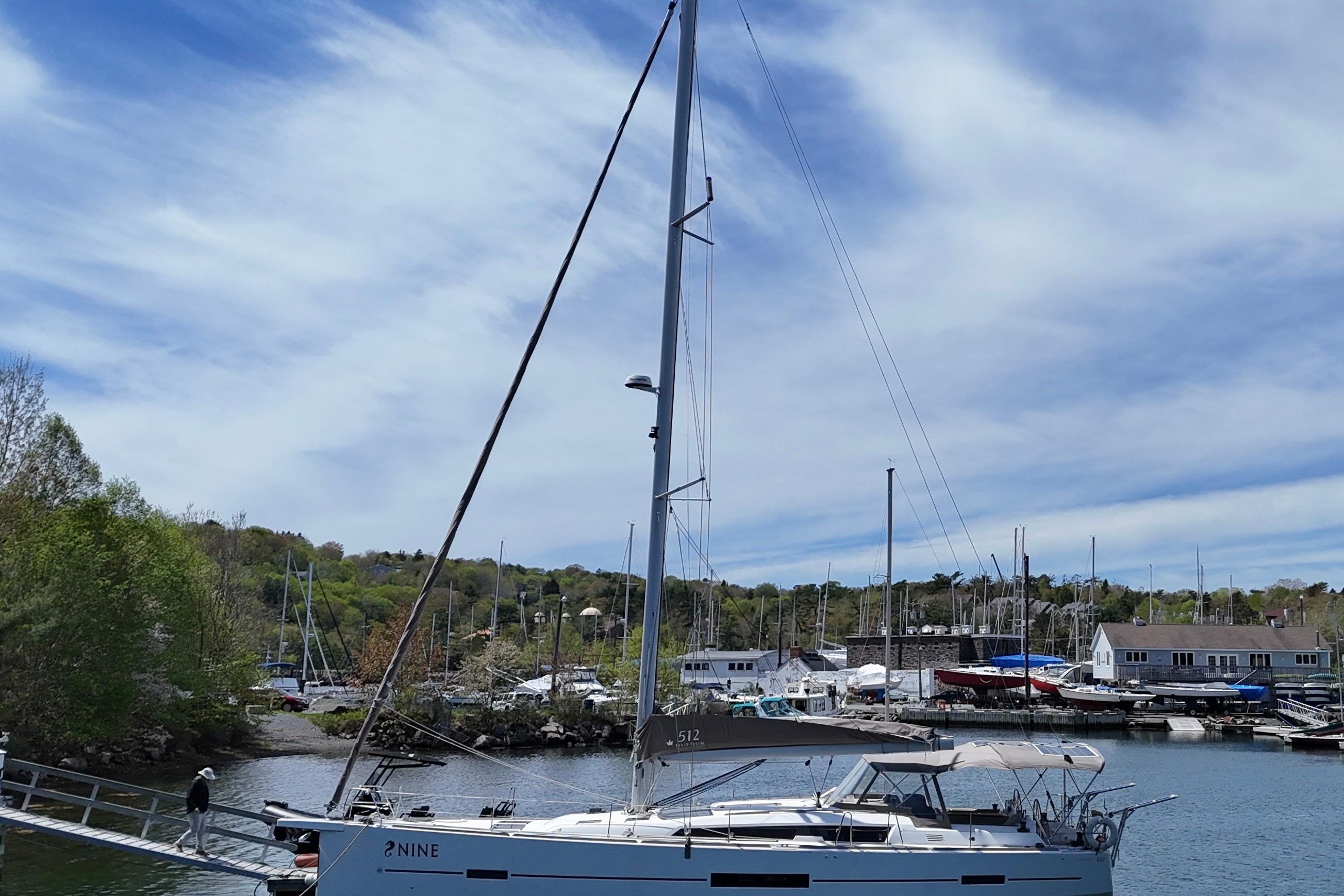 Sailing yacht Dufour 512 Grand Large 2016 docked in a scenic marina.