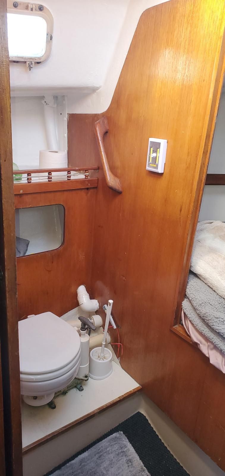 Interior of a yacht with a toilet and wooden paneling.