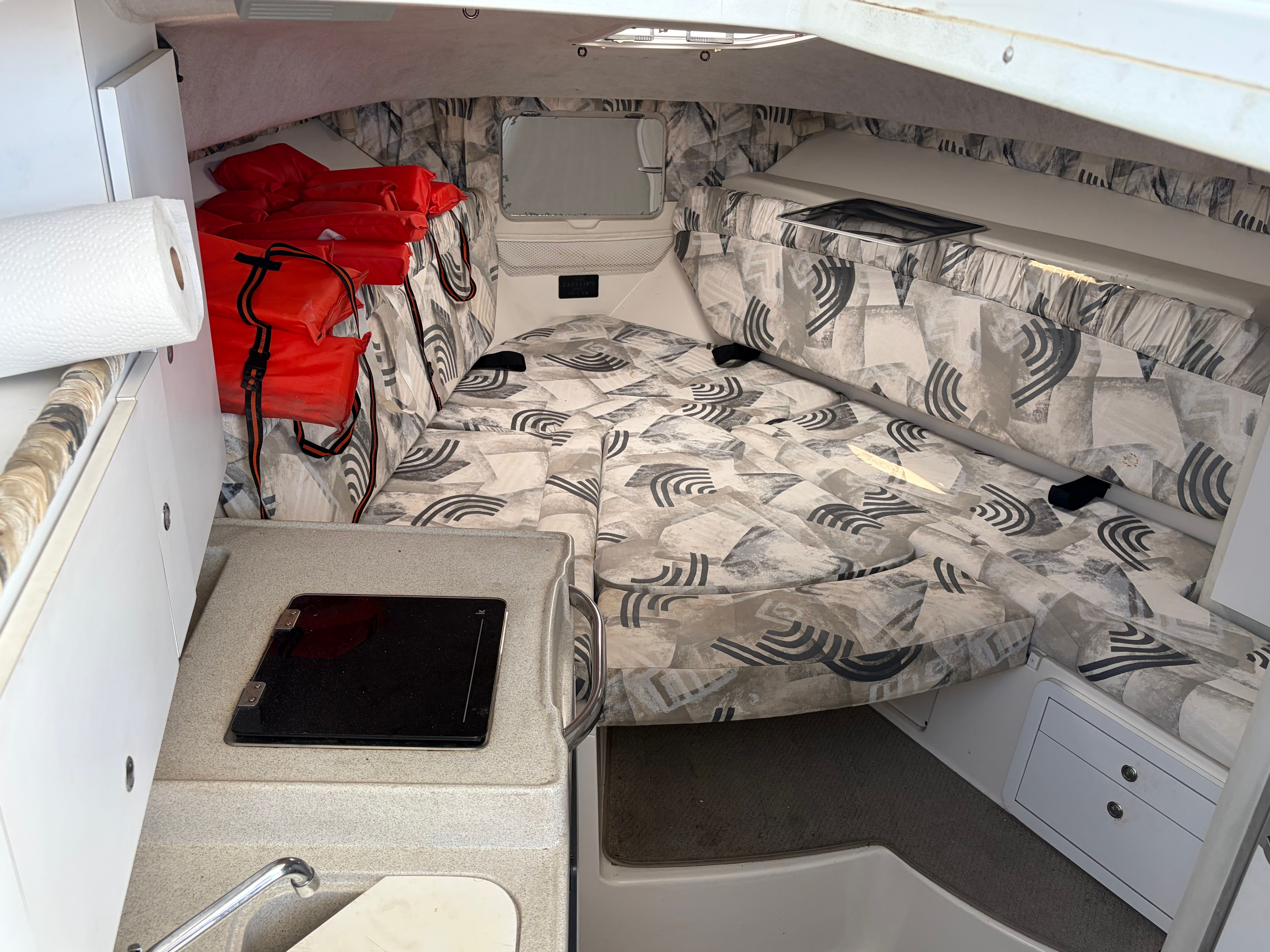 Interior of a 2000 Wellcraft 290 Coastal with patterned cushions and life jackets.