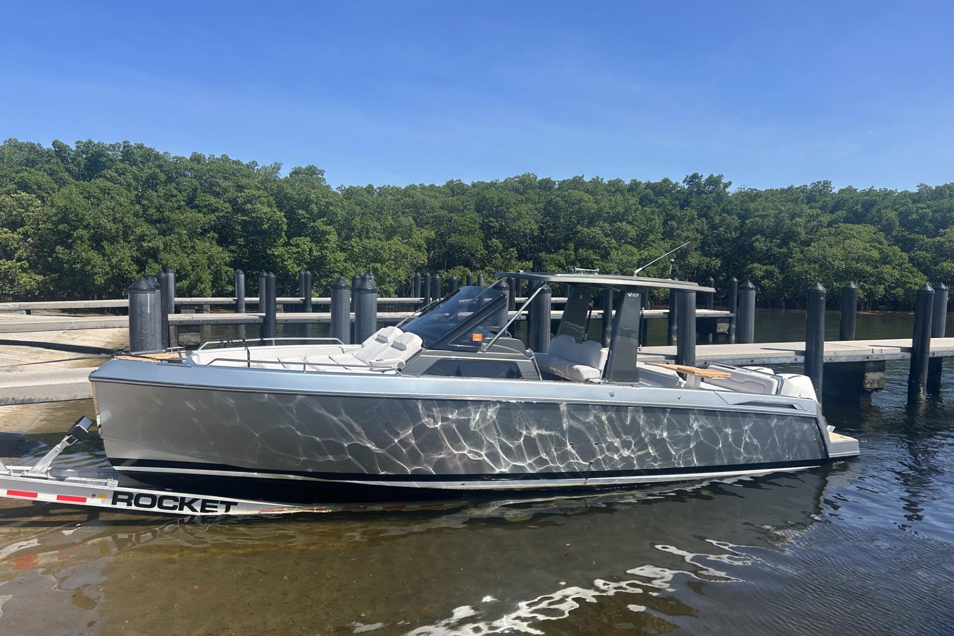 2023 Schaefer V33 boat docked on a sunny day, reflecting water patterns.