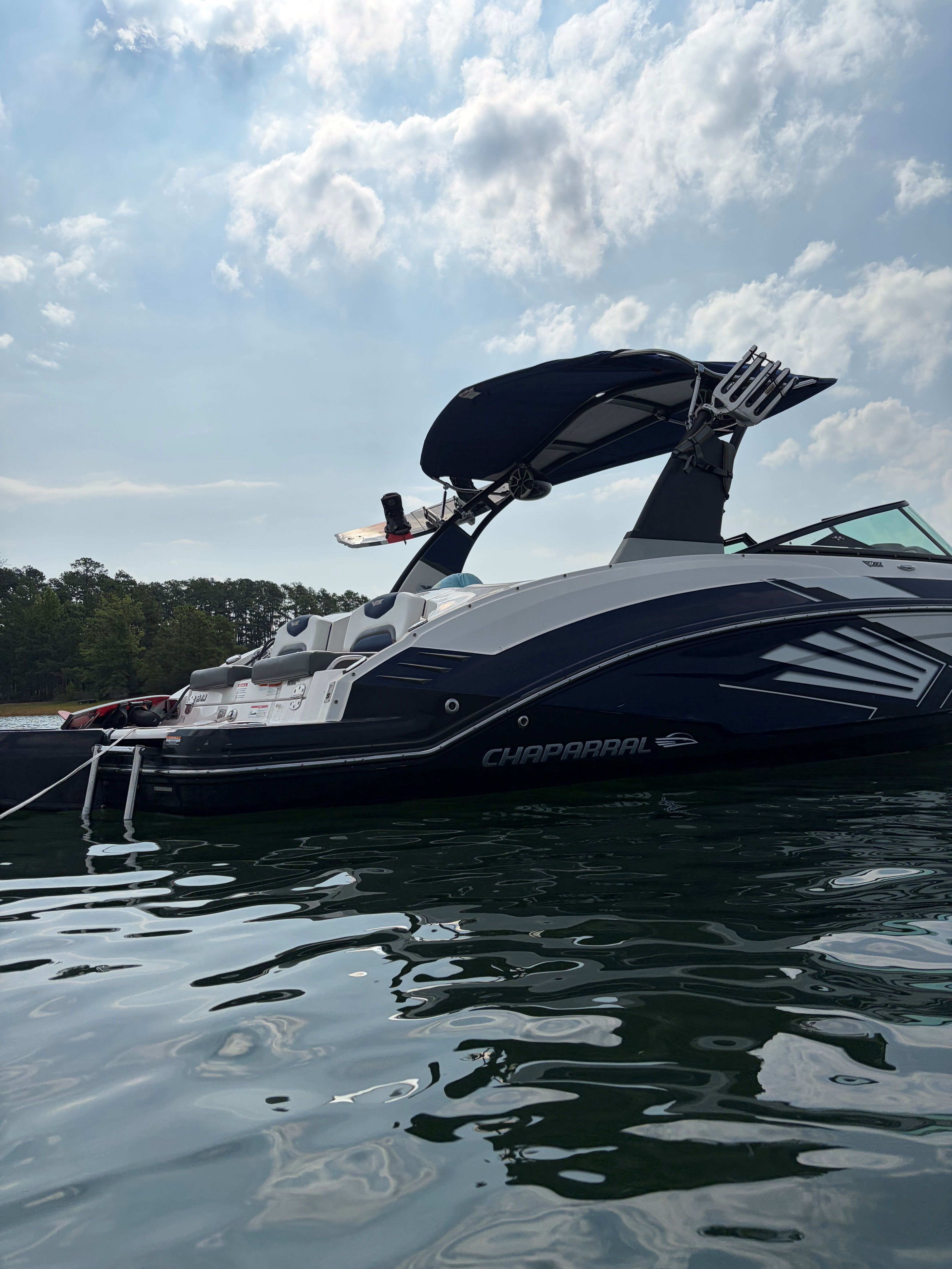 A 2015 Chaparral Vortex 243 VRX on calm water, featuring a black sunshade.