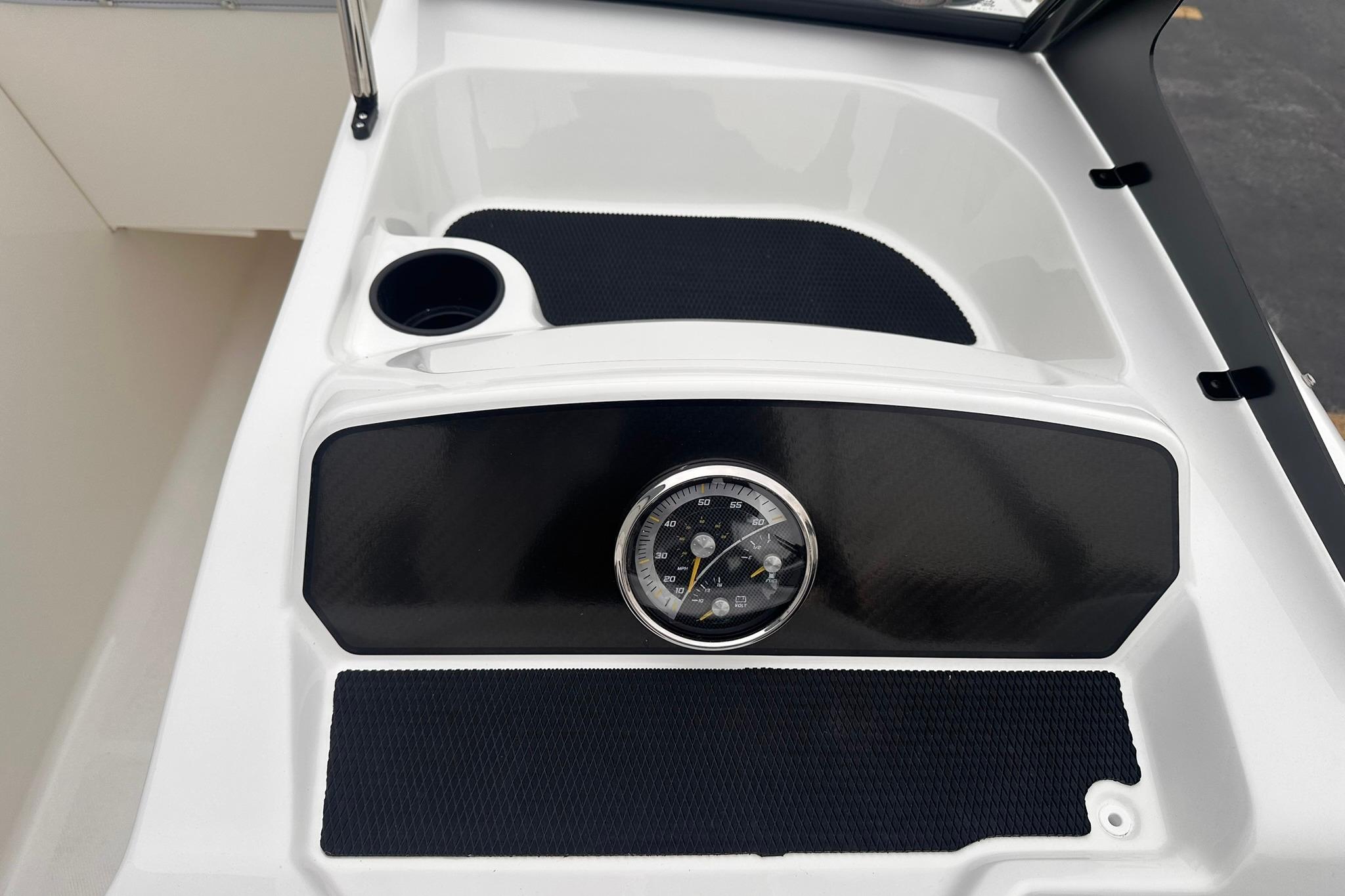 2026 Bayliner M17 dashboard with speedometer and cup holder, featuring sleek black and white design.