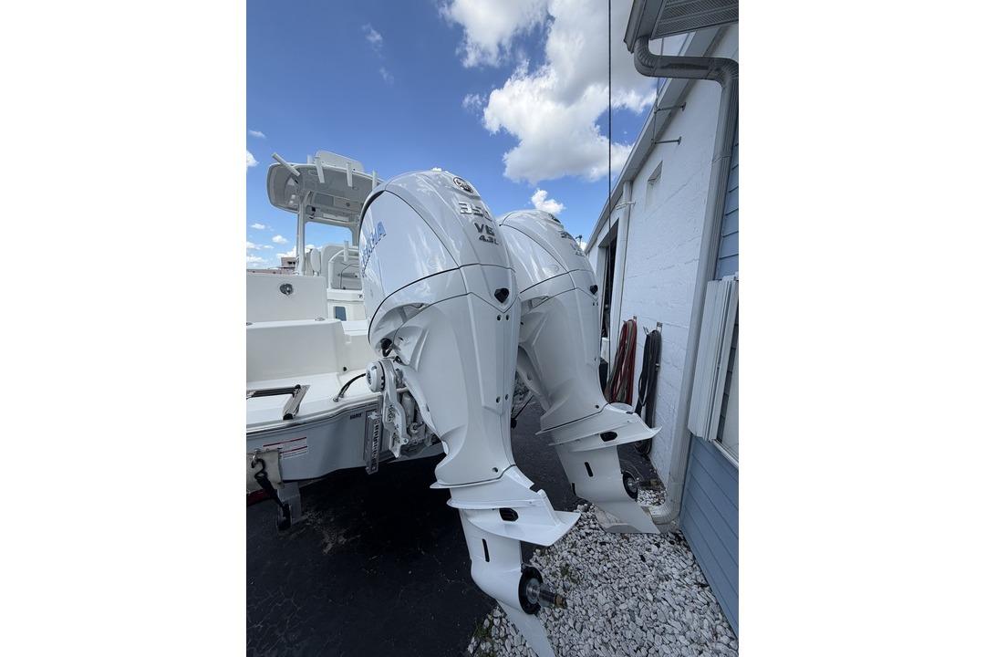 2026 Pathfinder 2800 Hybrid boat with dual outboard engines, parked outdoors.