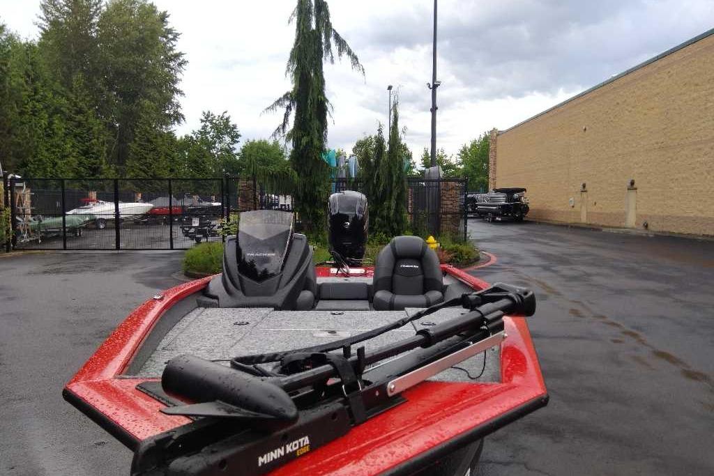 2026 Tracker Pro Team 175 boat with Minn Kota motor in a parking lot.