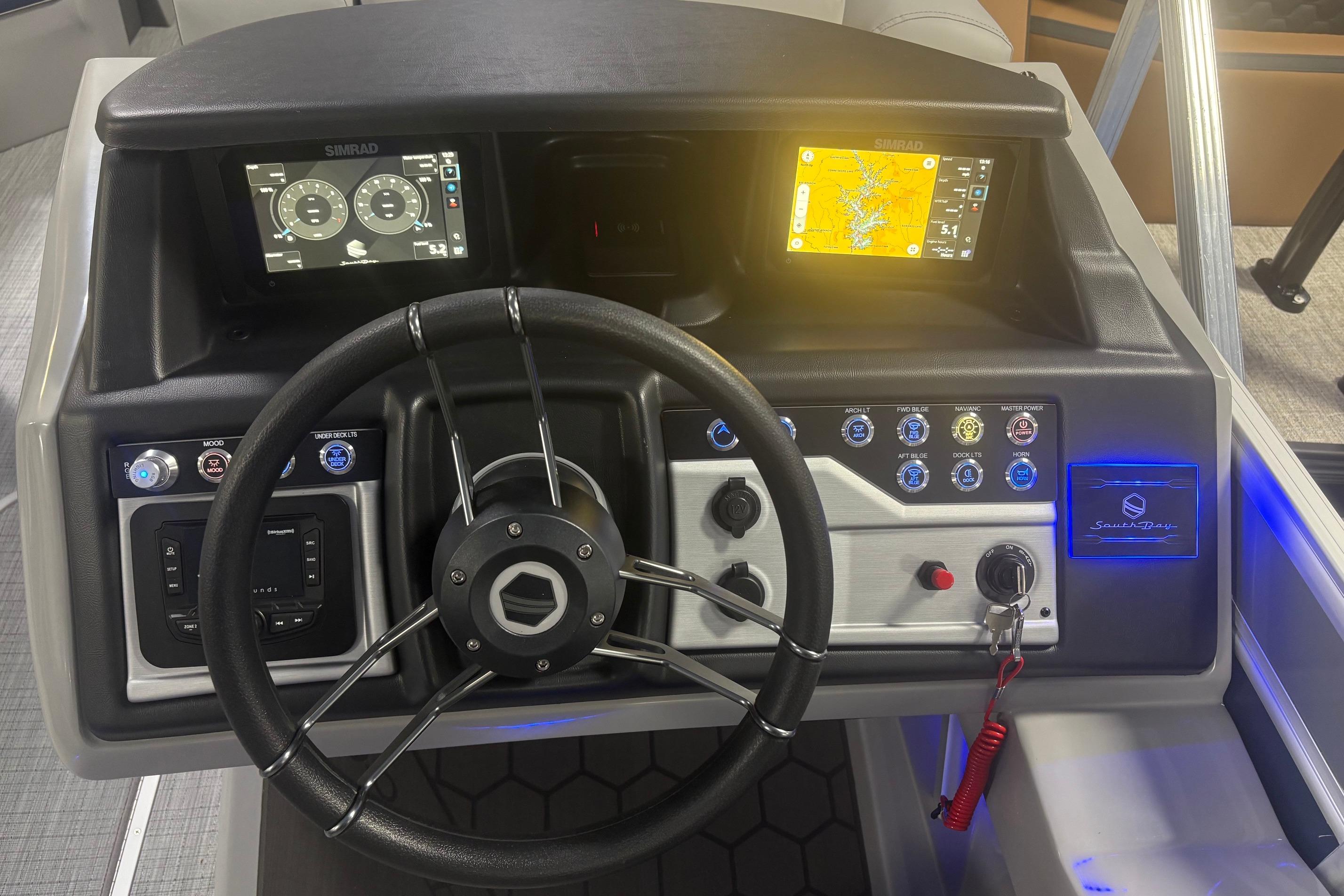 Steering console of 2026 South Bay 523RS boat with navigation screens and controls.
