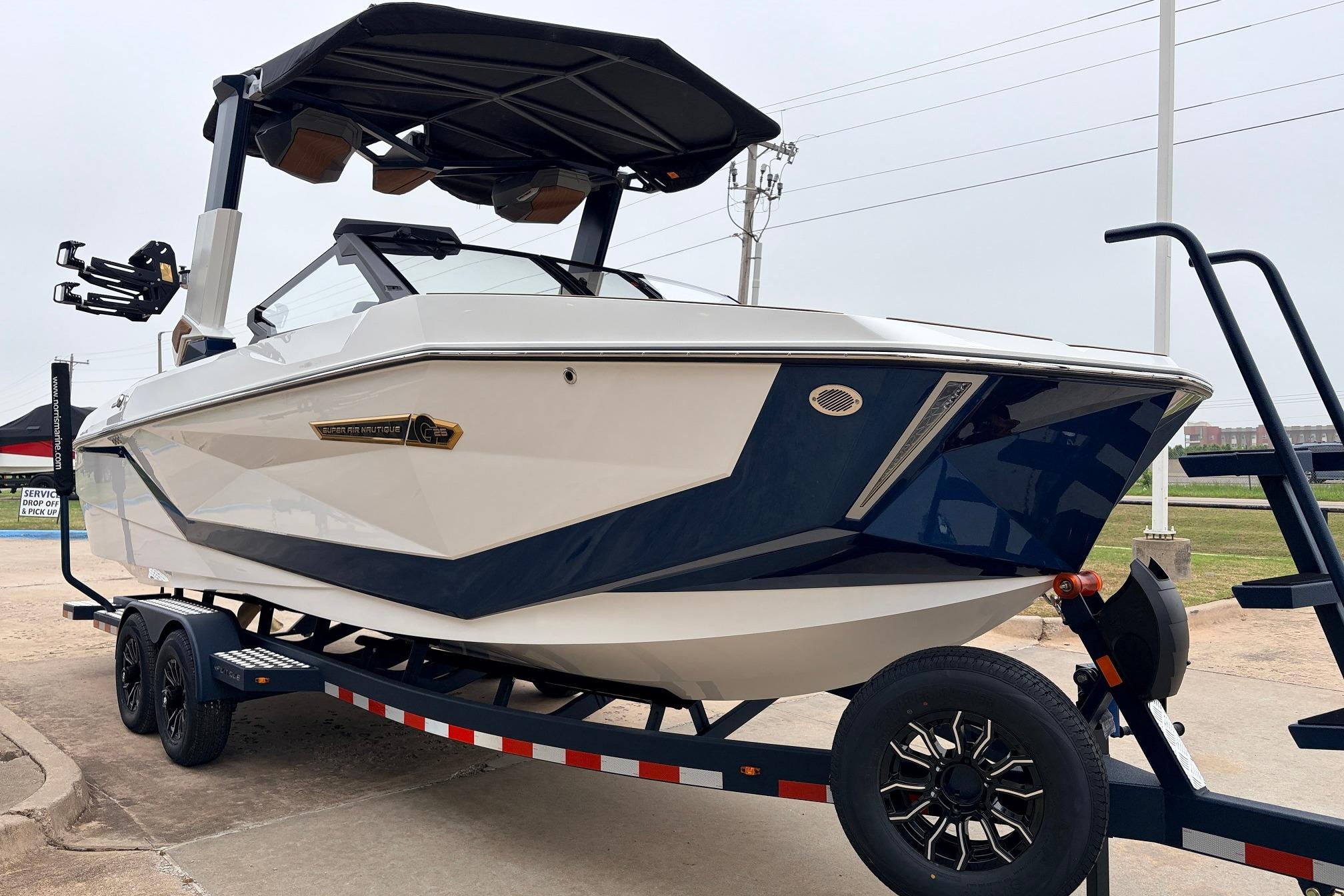 2026 Nautique Super Air Nautique G25 boat on trailer, sleek design, white and blue color.