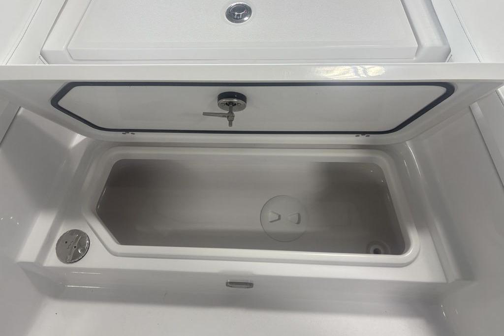 2026 Sportsman Masters 227 boat storage compartment with open lid and secure lock.