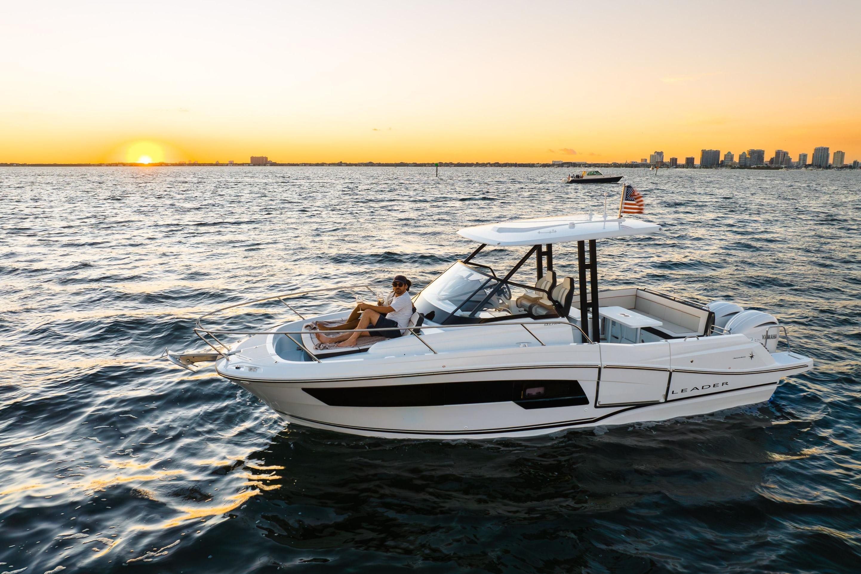 2026 Jeanneau Leader 9.0 WA cruising at sunset near city skyline.