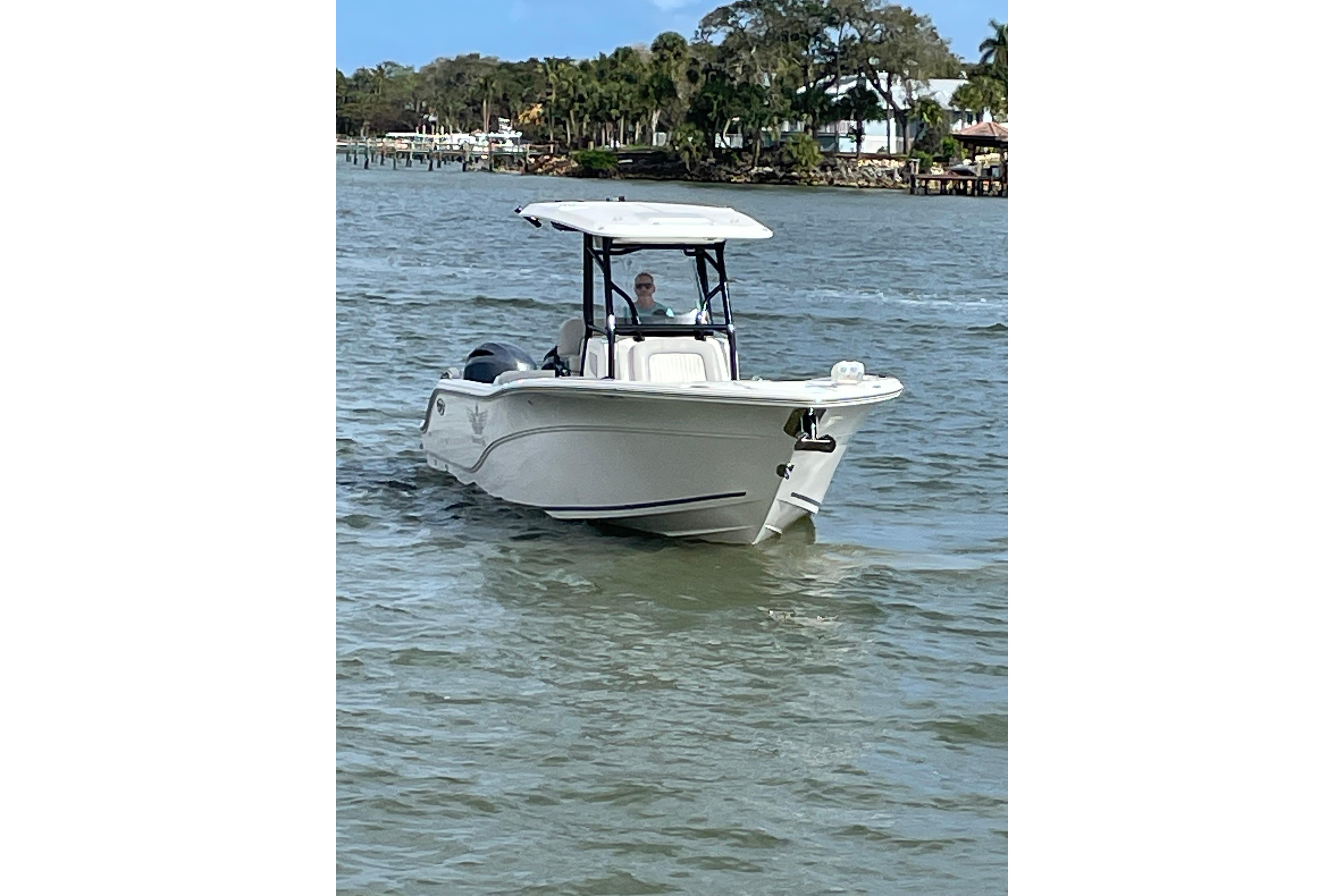 2023 Sea Fox 268 Commander boat cruising on a calm waterway.