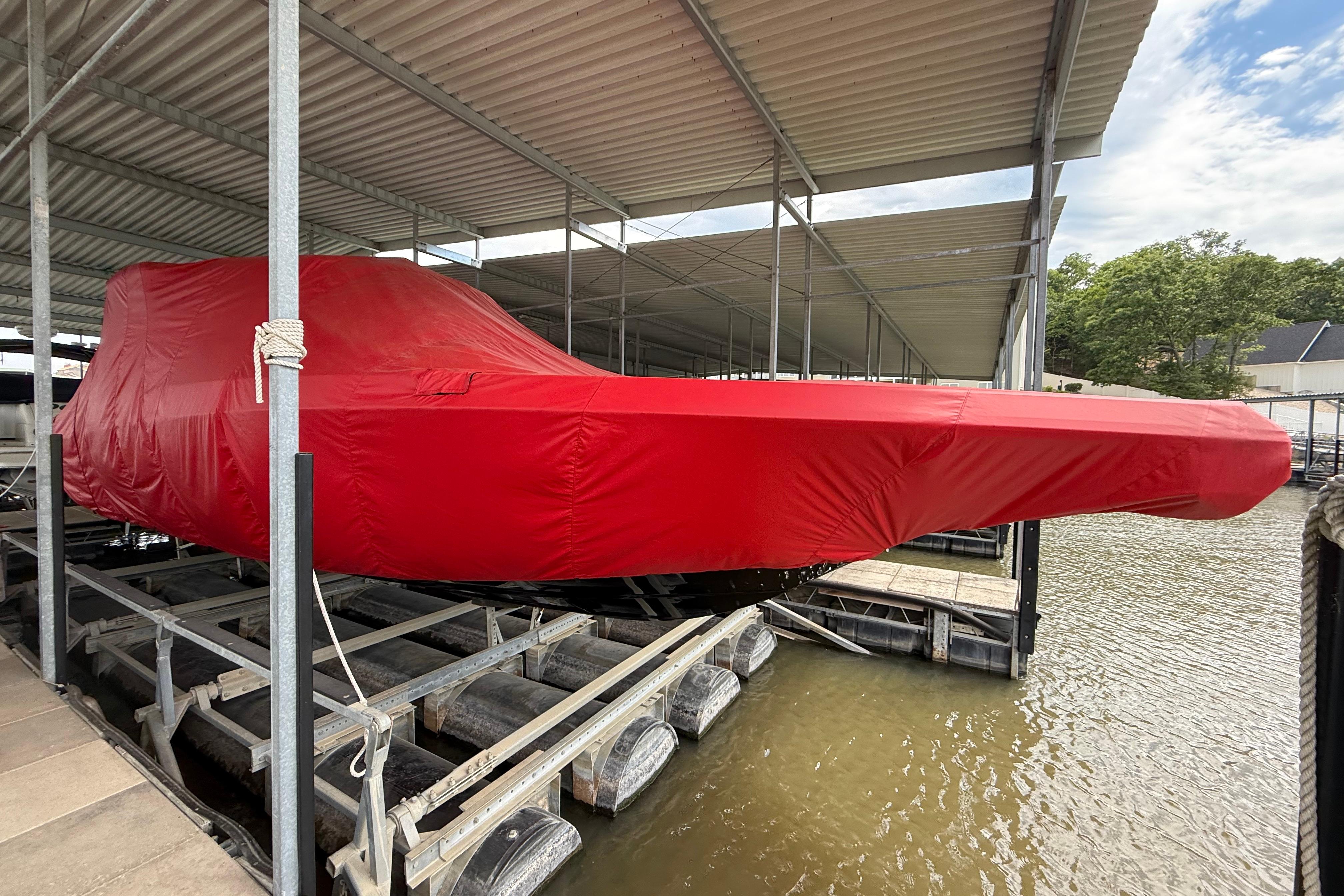 2025 Fountain 38 SCX boat covered in red tarp, docked at marina.