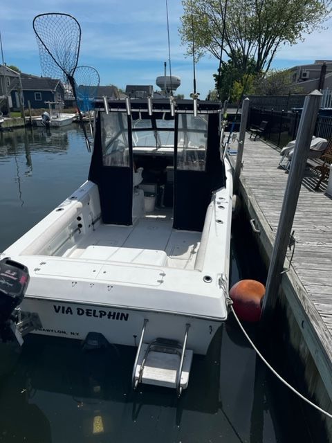 A 1998 Sport-Craft 252 Sport Fish boat docked. It features an open cabin and fishing gear.