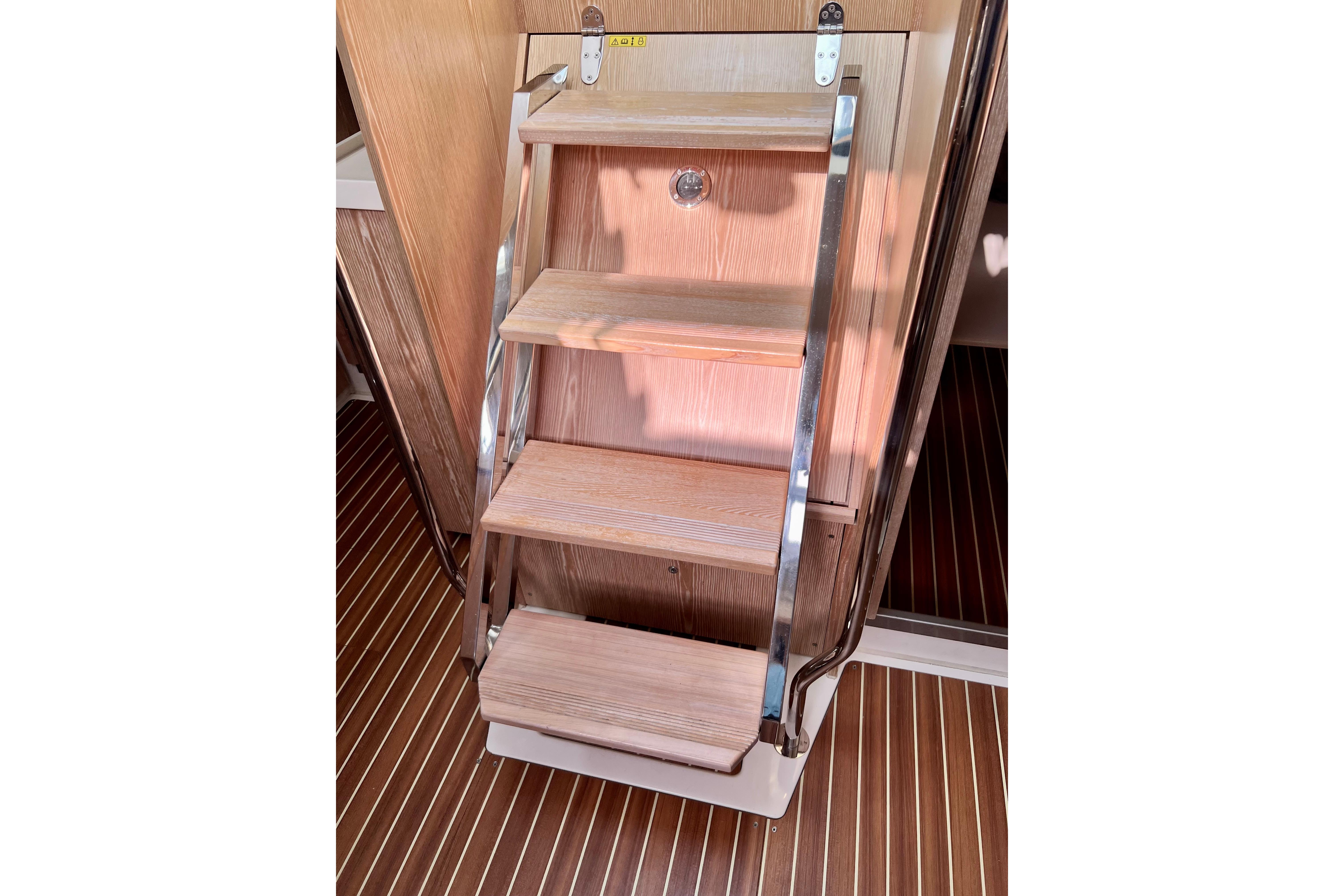 Wooden steps with metal rails inside a 2016 Hanse 455 yacht.