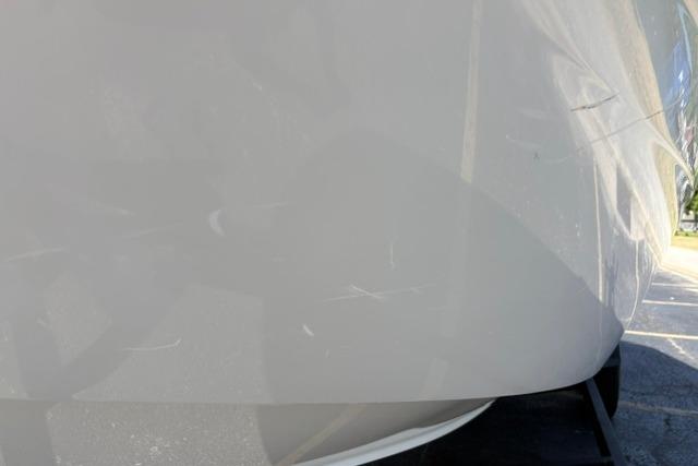 2024 Tahoe T21 boat hull with visible scratches in sunlight.