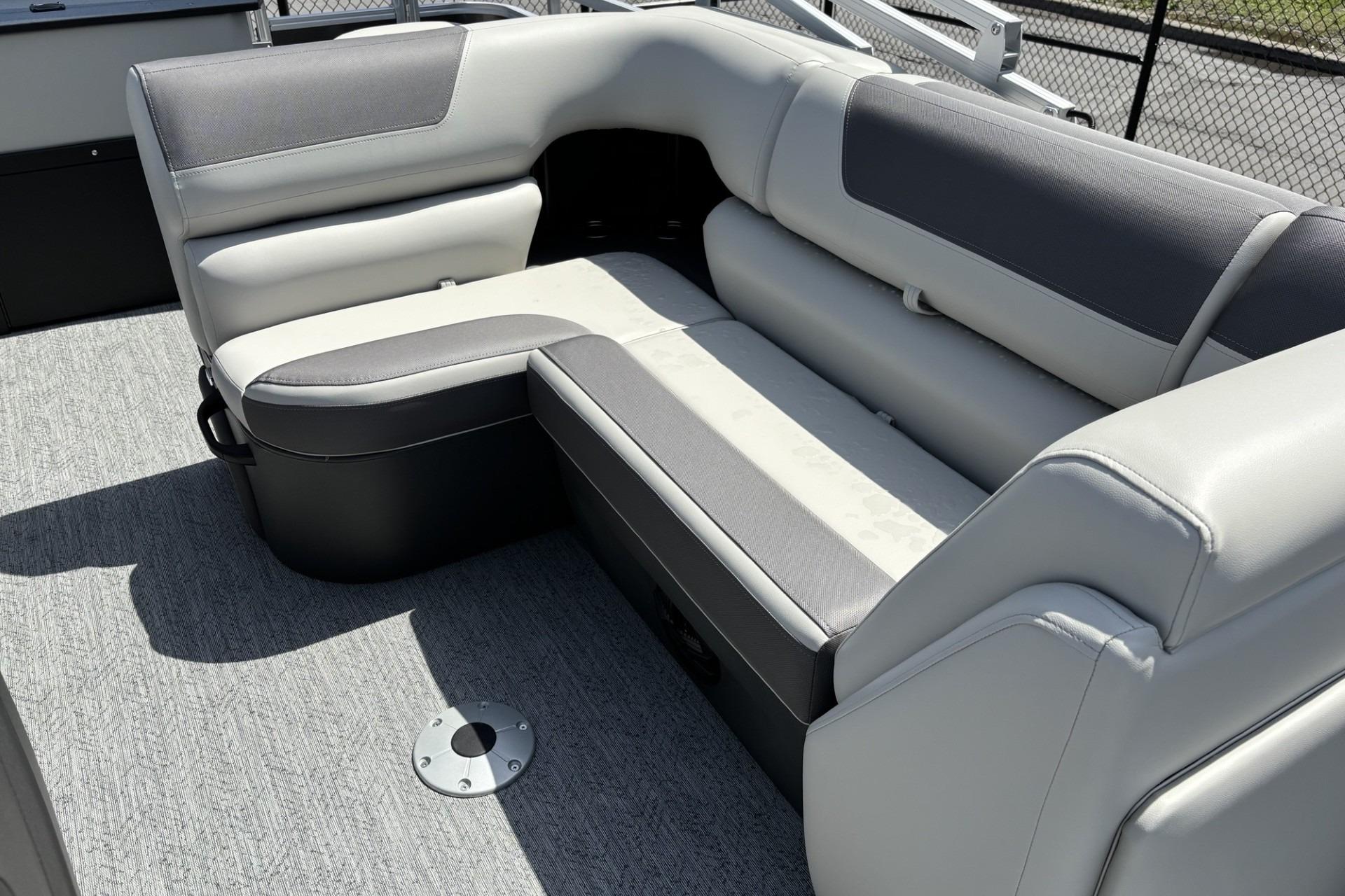 2026 Sun Tracker Fishin' Barge 20 DLX interior seating with gray upholstery and carpeted flooring.