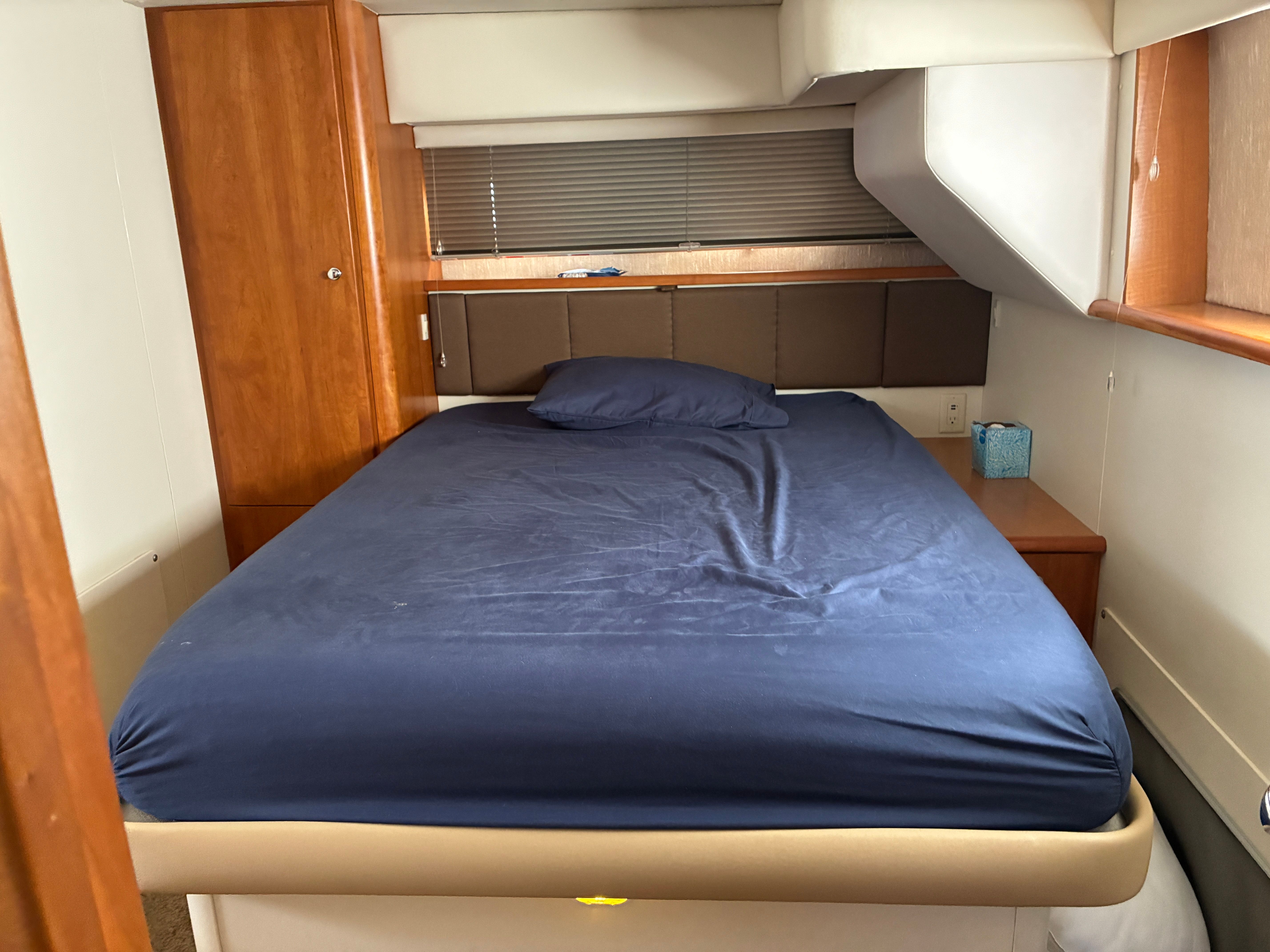 The image shows a cozy cabin with a double bed and wooden furnishings.