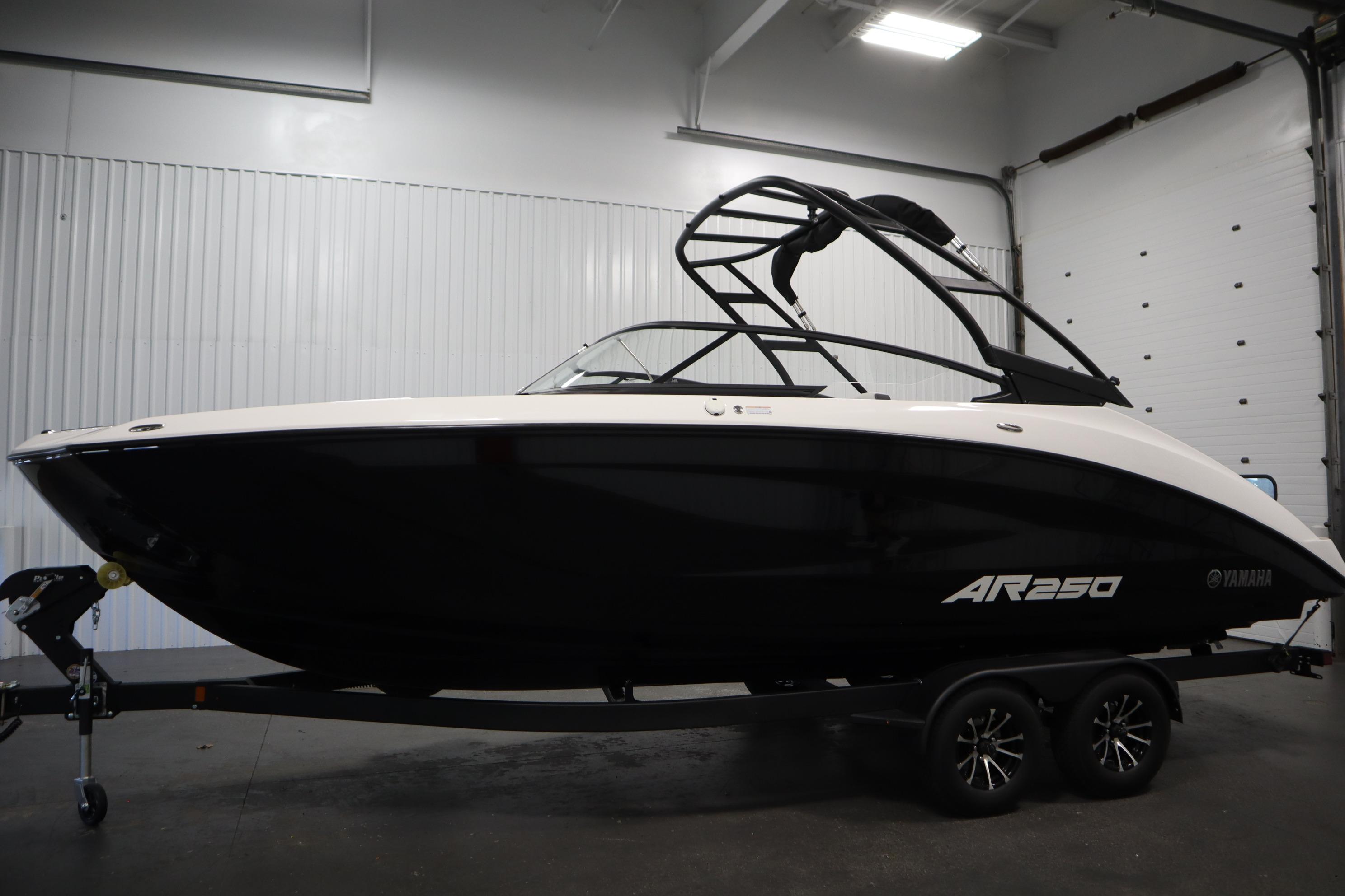 2026 Yamaha AR250 boat in a showroom, sleek black and white design on a trailer.
