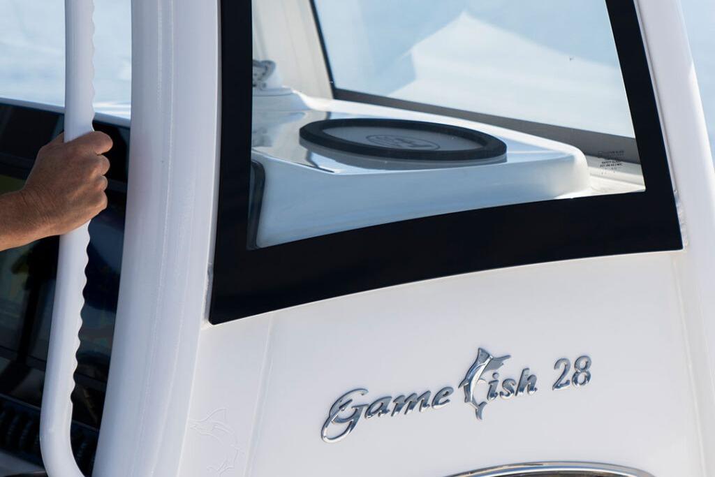 2026 Sea Hunt Gamefish 28 Coffin Box boat detail with hand on railing.