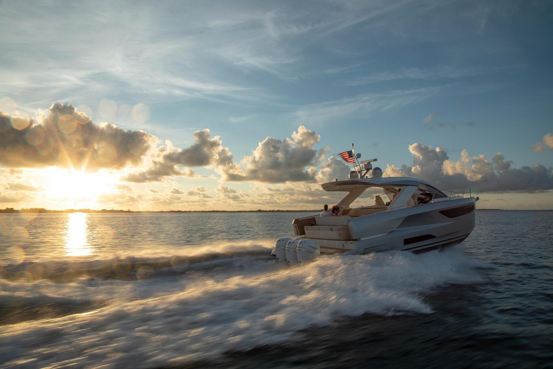 2027 Jeanneau DB/43 OB yacht cruising at sunset on open water.