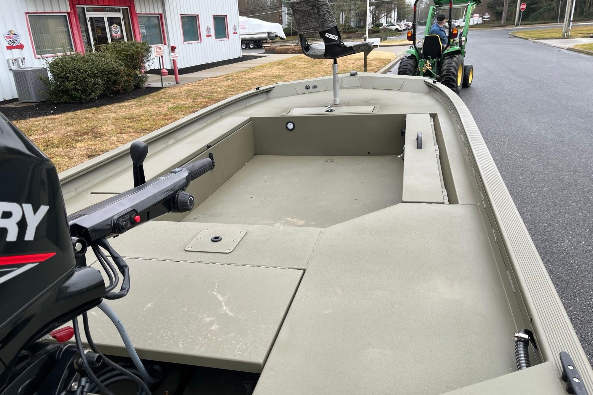 2026 Tracker Grizzly 1654 T Sportsman boat with Mercury engine, parked outdoors.