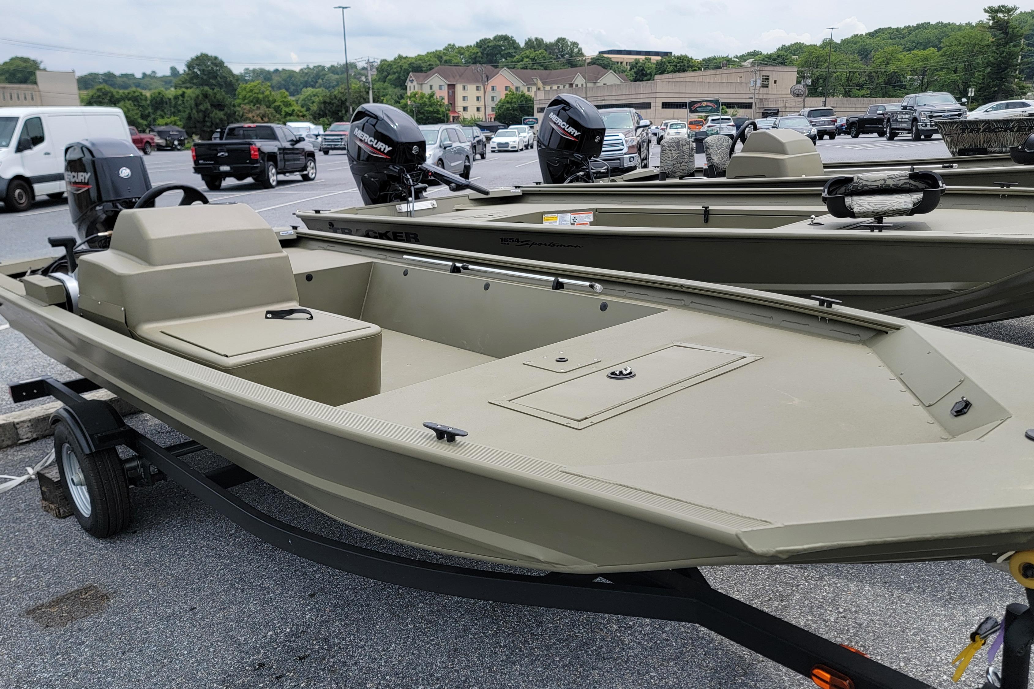 2026 Tracker Grizzly 1648 SC boat on trailer in parking lot.