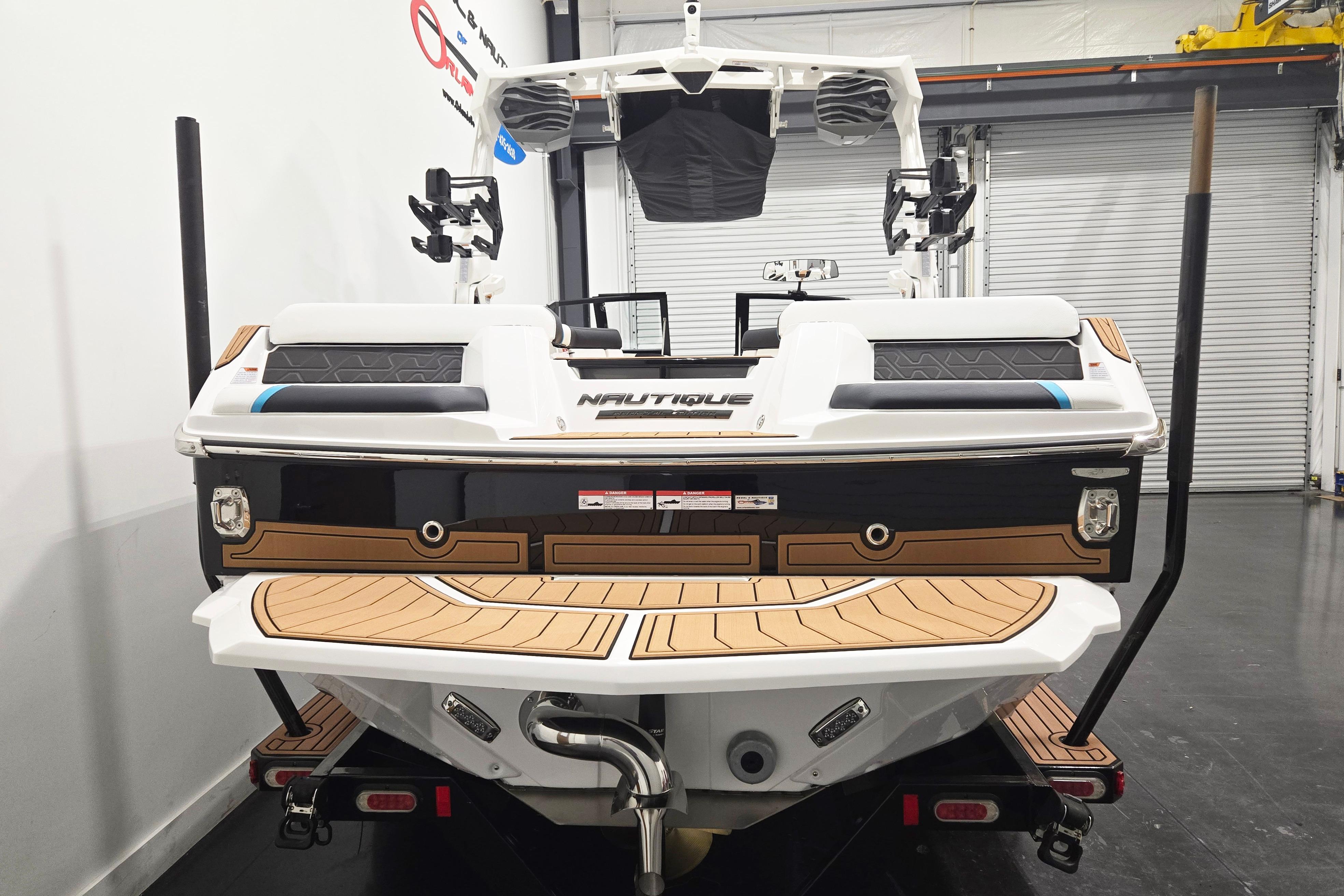 2026 Nautique Super Air Nautique GS22 boat, rear view in a showroom setting.