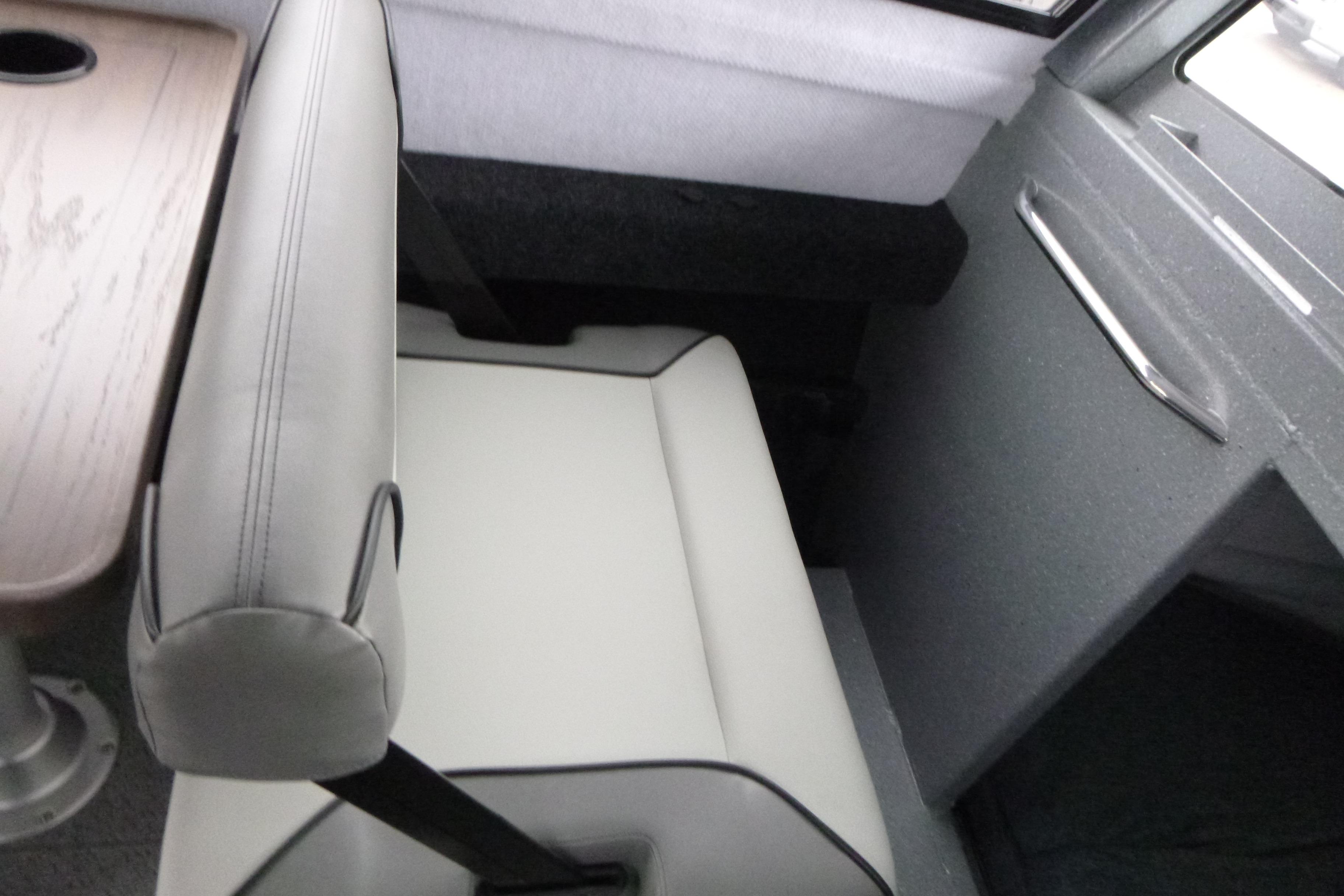 Interior seating of 2026 KingFisher 25 XAC boat with table and window view.
